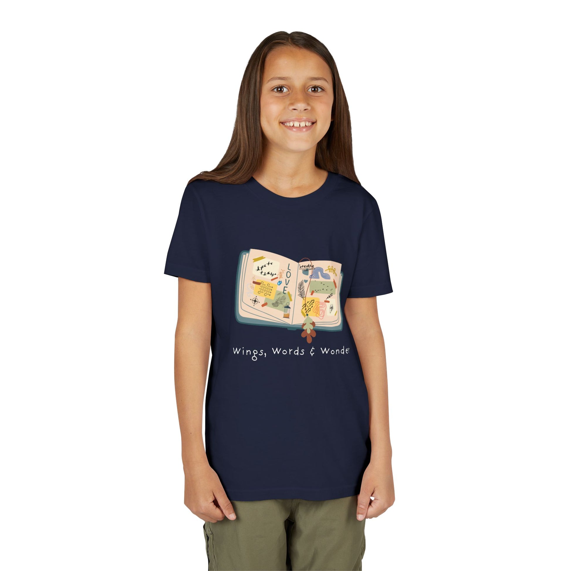 Girl wearing a navy blue t-shirt with an open scrap book  and text 'Wings, Words & Wonder' 