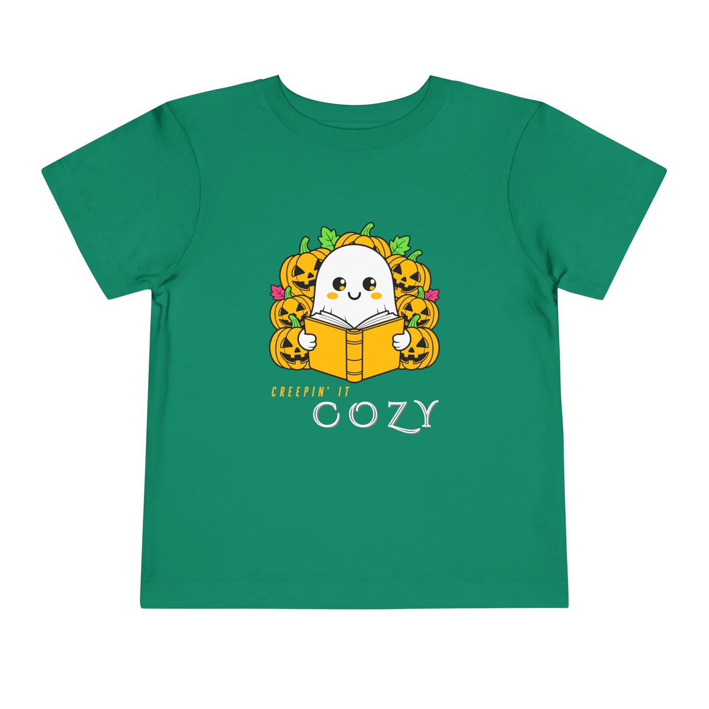 Green toddler t-shirt with a ghost reading a book in pumpkin patch and text 'Creepin' It Cozy'
