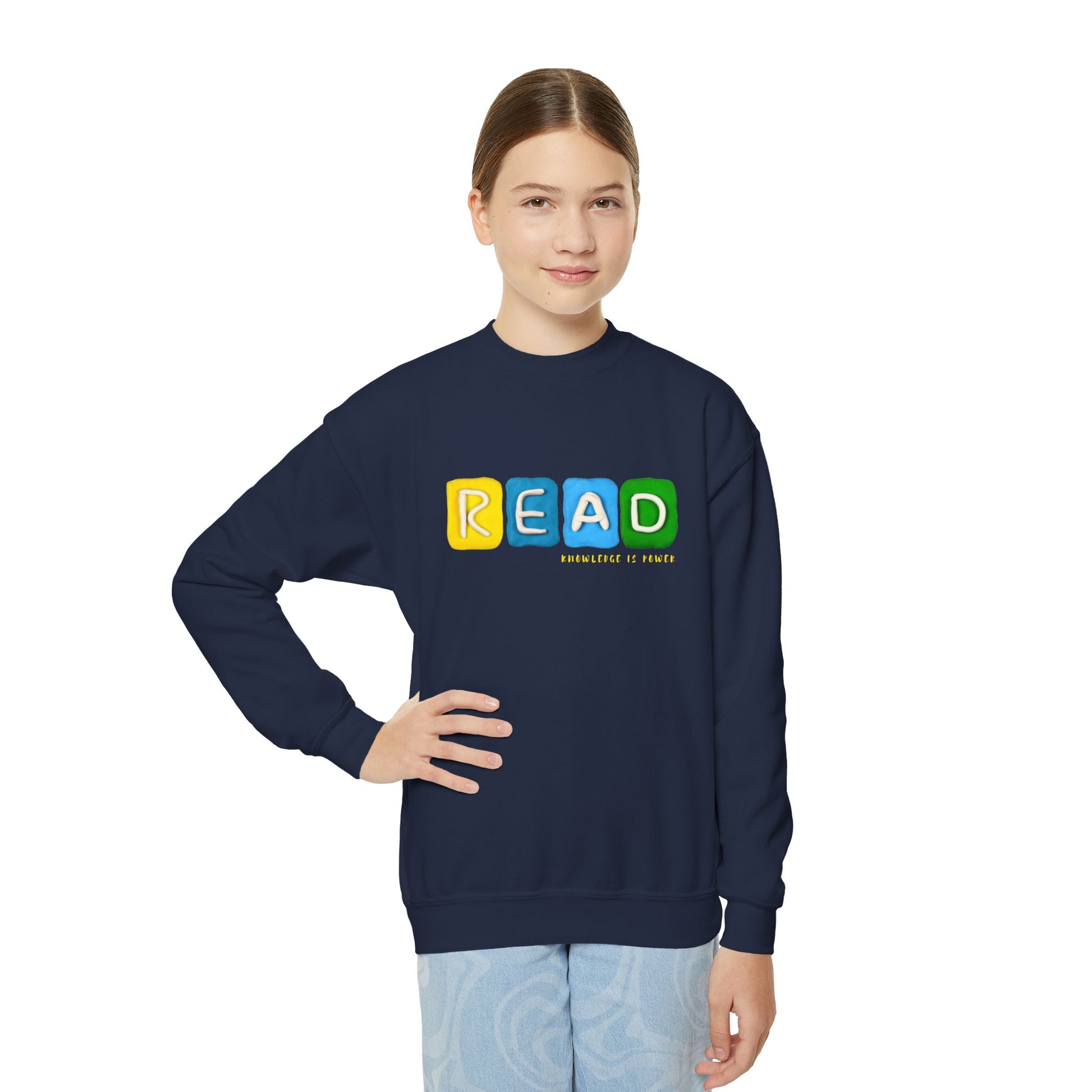 Girl wearing a navy blue sweatshirt with colorful clay sculpted to spell 'READ'