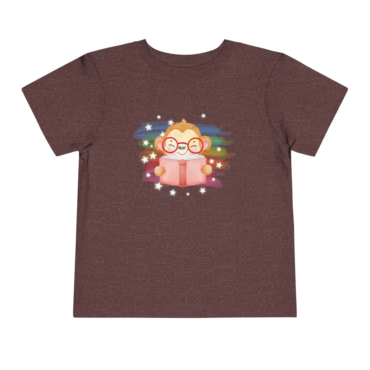 Maroon t-shirt with a cartoon monkey reading a book, lit up by rainbow watercolor rainbow and stars