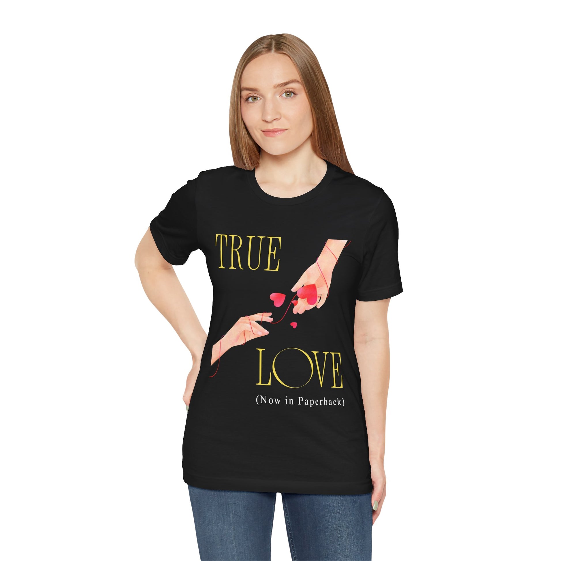 Woman wearing a black t-shirt with 'True Love (Now in Paperback)' text and graphic of two hands reaching foreach other, entwined in red string and hearts
