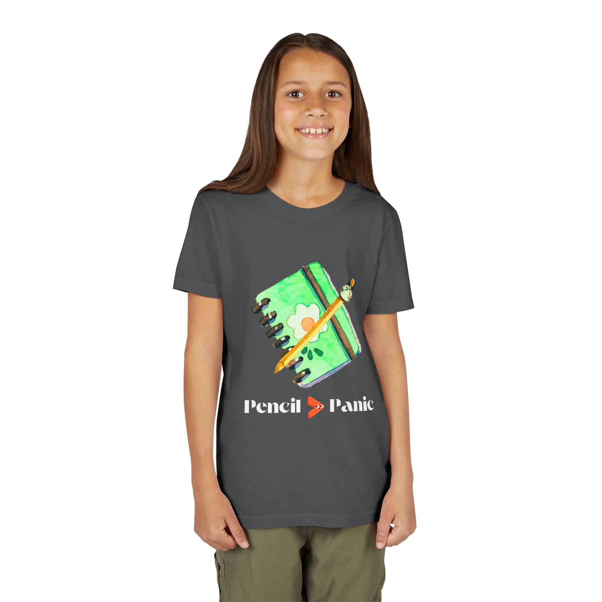 Girl wearing a gray t-shirt with a green notebook and pencil graphic and 'Pencil > Panic' text