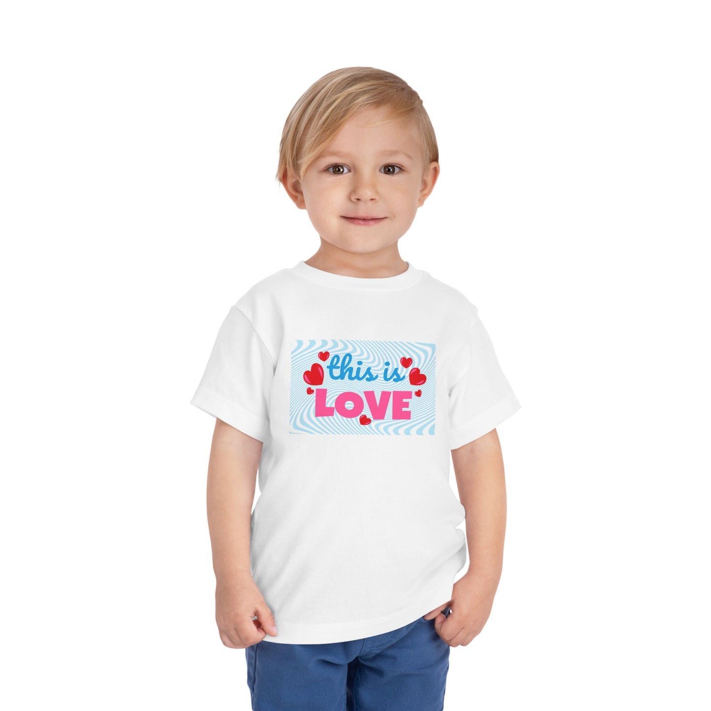 Toddler wearing a white t-shirt with 'this is LOVE' text and heart graphics on a swirling blue background