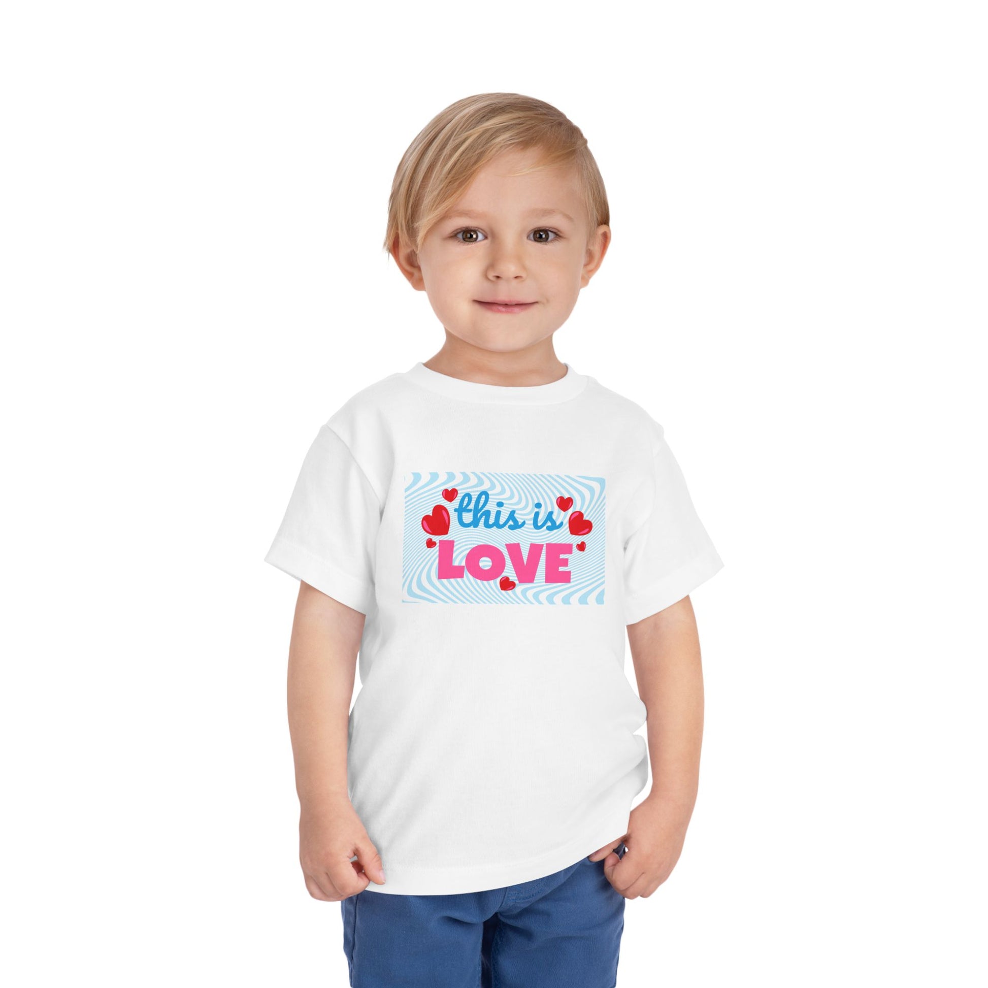 Toddler wearing a white t-shirt with 'this is LOVE' text and heart graphics on a swirling blue background