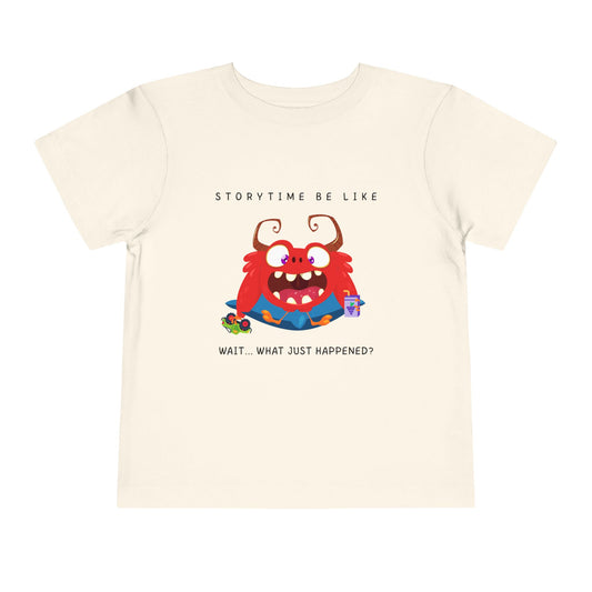 Beige toddler t-shirt with a cartoon monster holding a toy and a juice box, text 'Storytime be like wait...what just happened?'