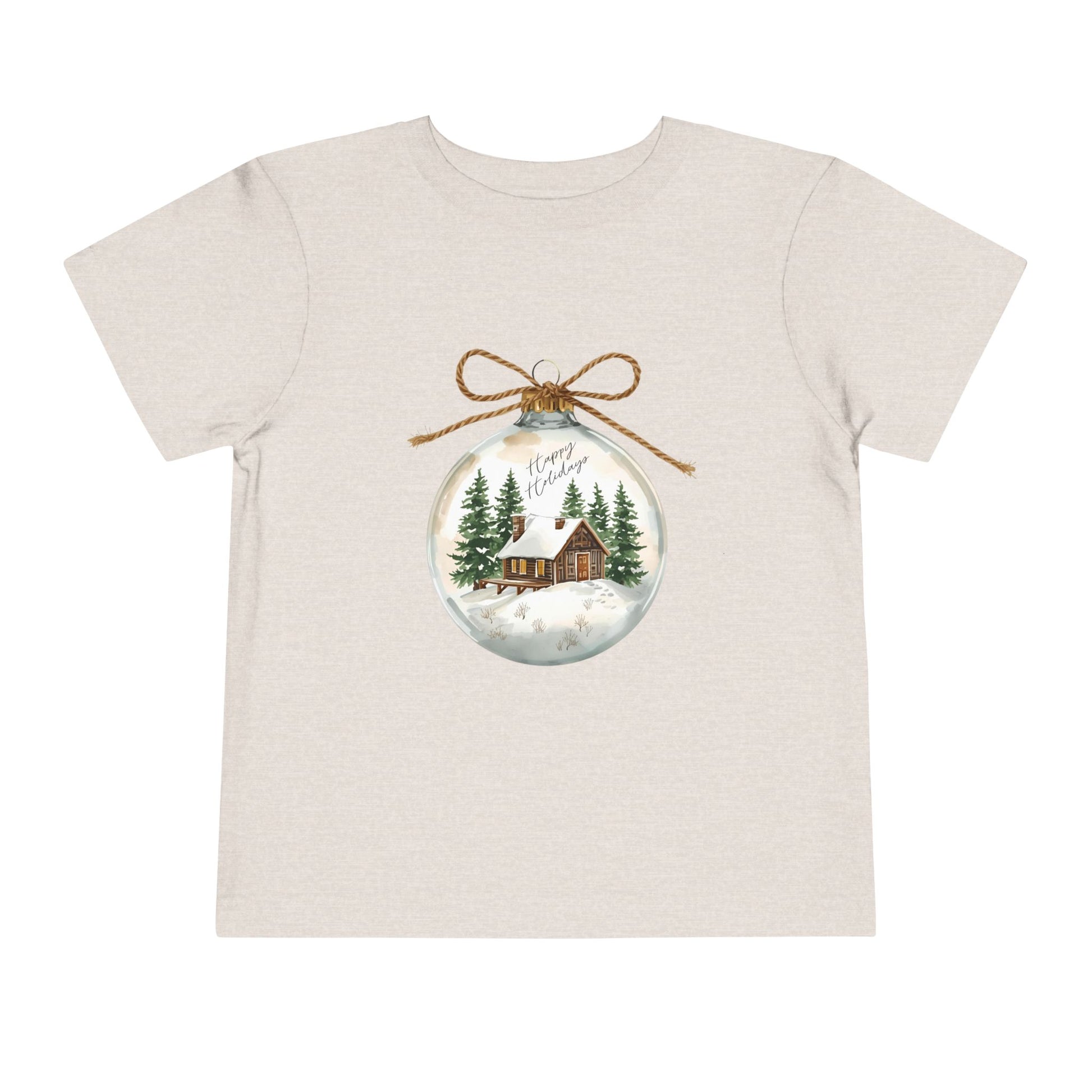 Beige/tan toddler t-shirt with a Christmas-themed ornament graphic featuring a cabin and trees 