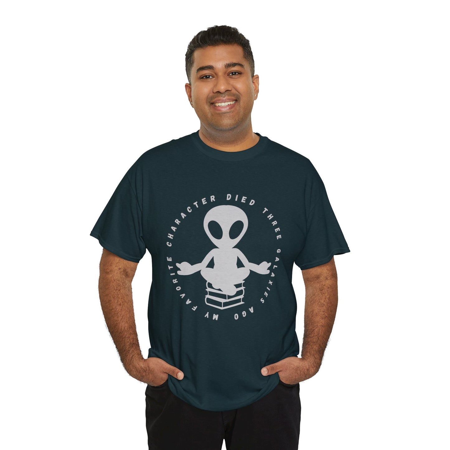Man wearing a dark t-shirt with meditating alien sitting on a stack of books, circled by text 'My Favorite Character Died Three Galaxies Ago' 