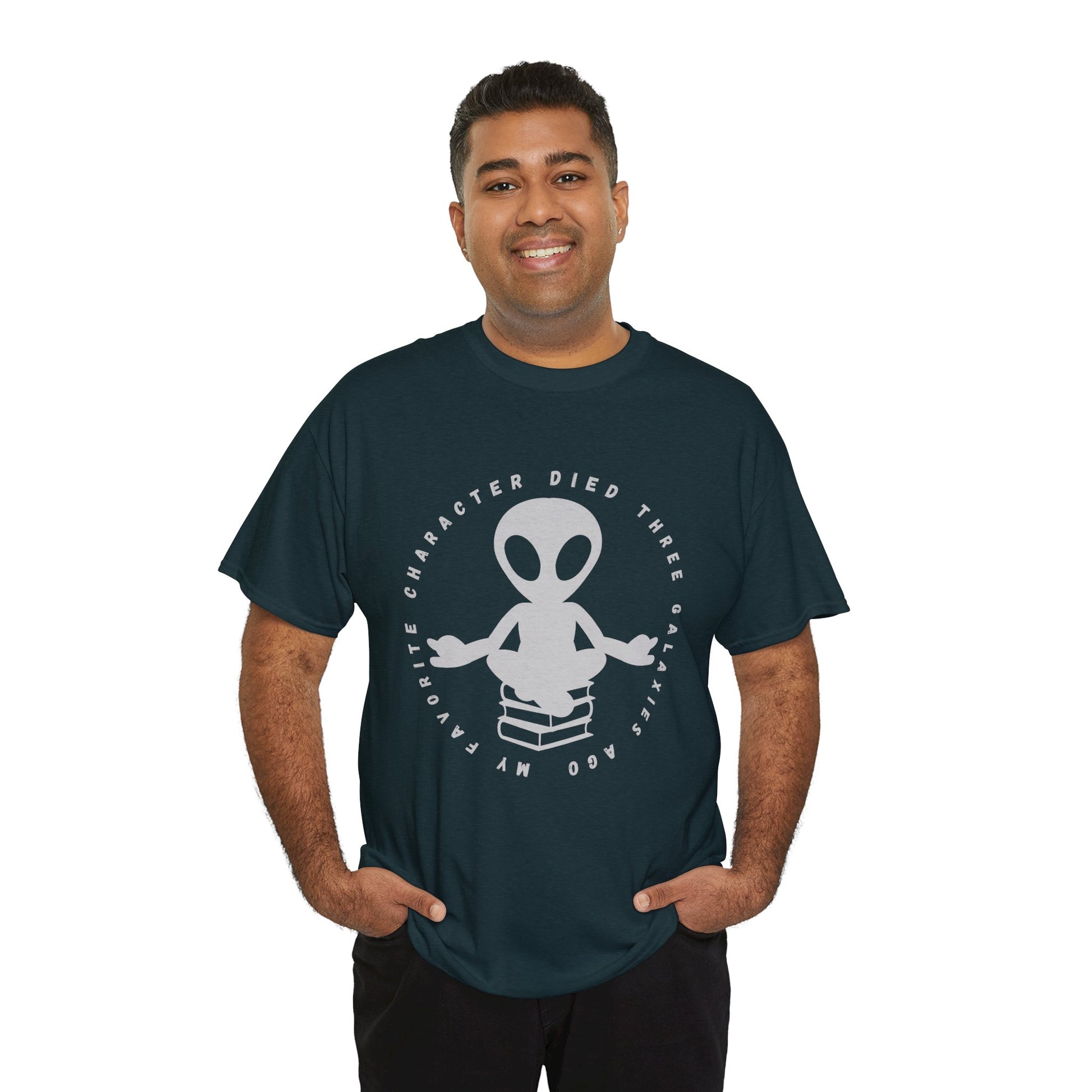 Man wearing a dark t-shirt with meditating alien sitting on a stack of books, circled by text 'My Favorite Character Died Three Galaxies Ago' 