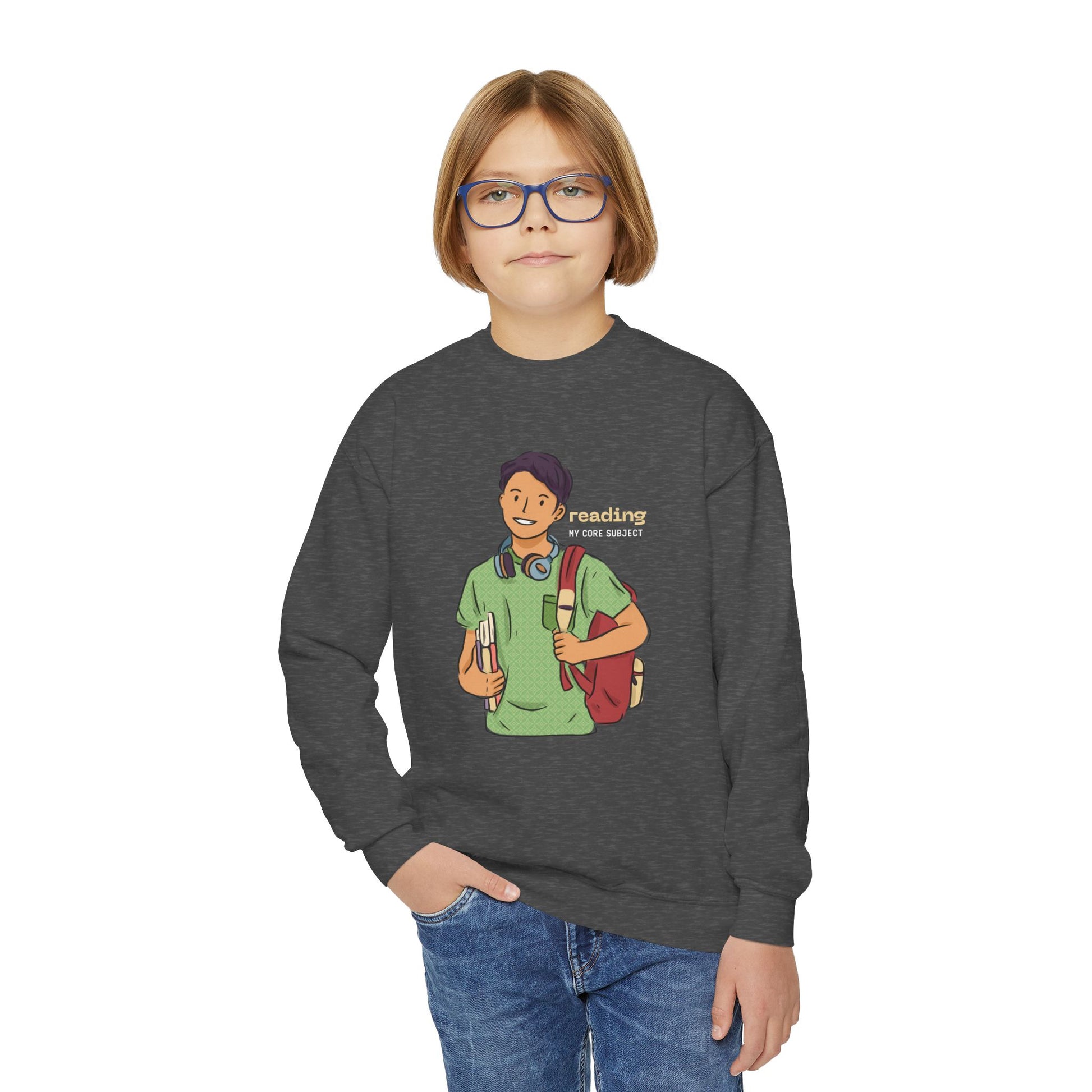 Boy wearing a dark gray sweatshirt with a graphic of a person holding books, carrying a backpack and text 'Reading: My Core Subject'
