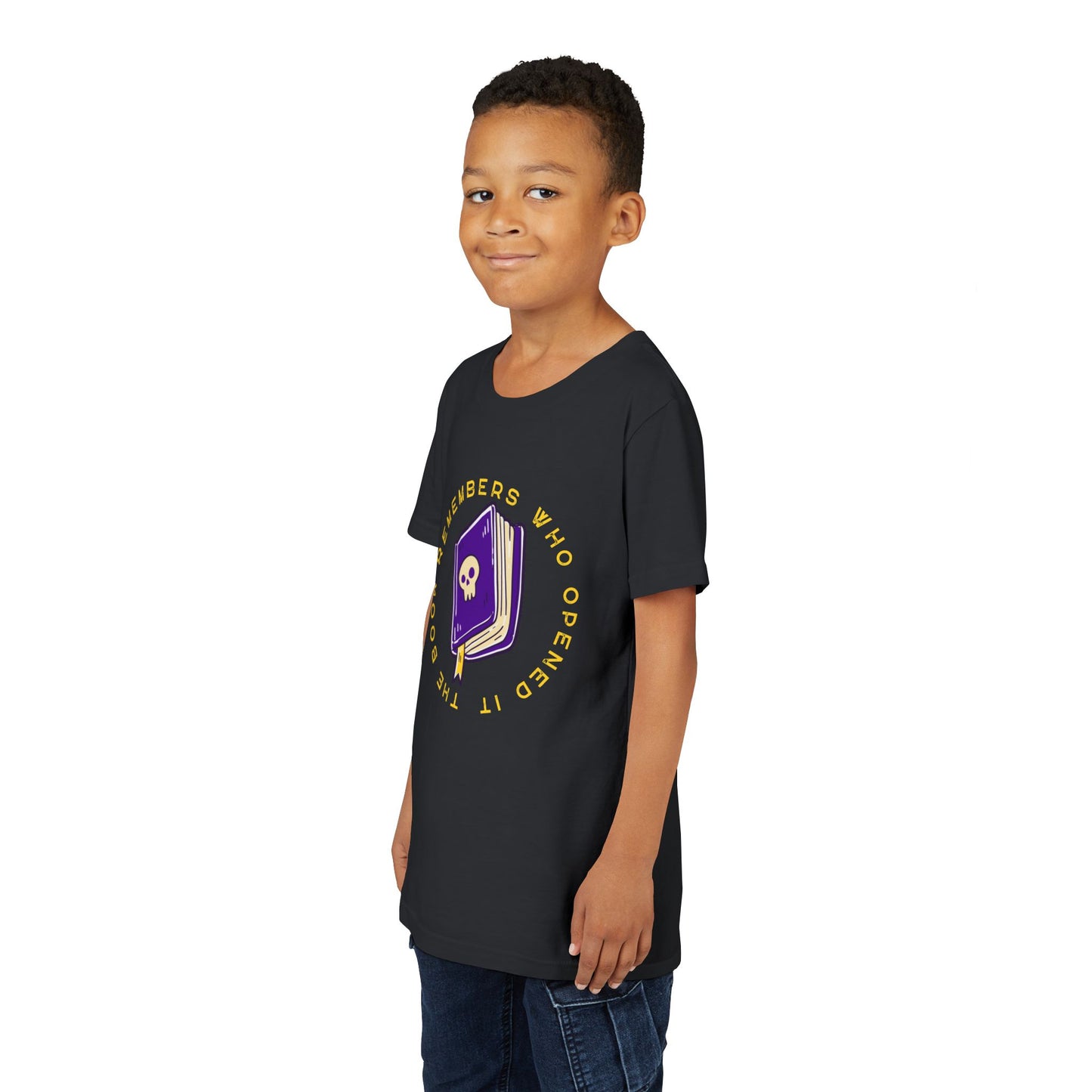 Boy wearing a black t-shirt with a purple book graphic, featuring a skull on the cover and surrounded by yellow text 'The Book Remembers Who Opened It'