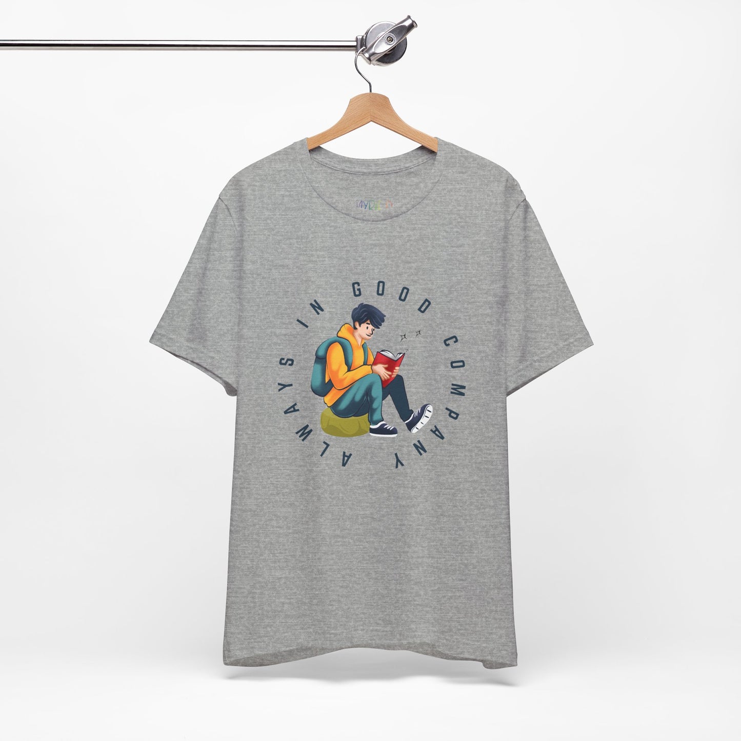 Light gray t-shirt with a graphic design of a person reading a book, sitting on a green bag, with text 'Always In Good Company' 