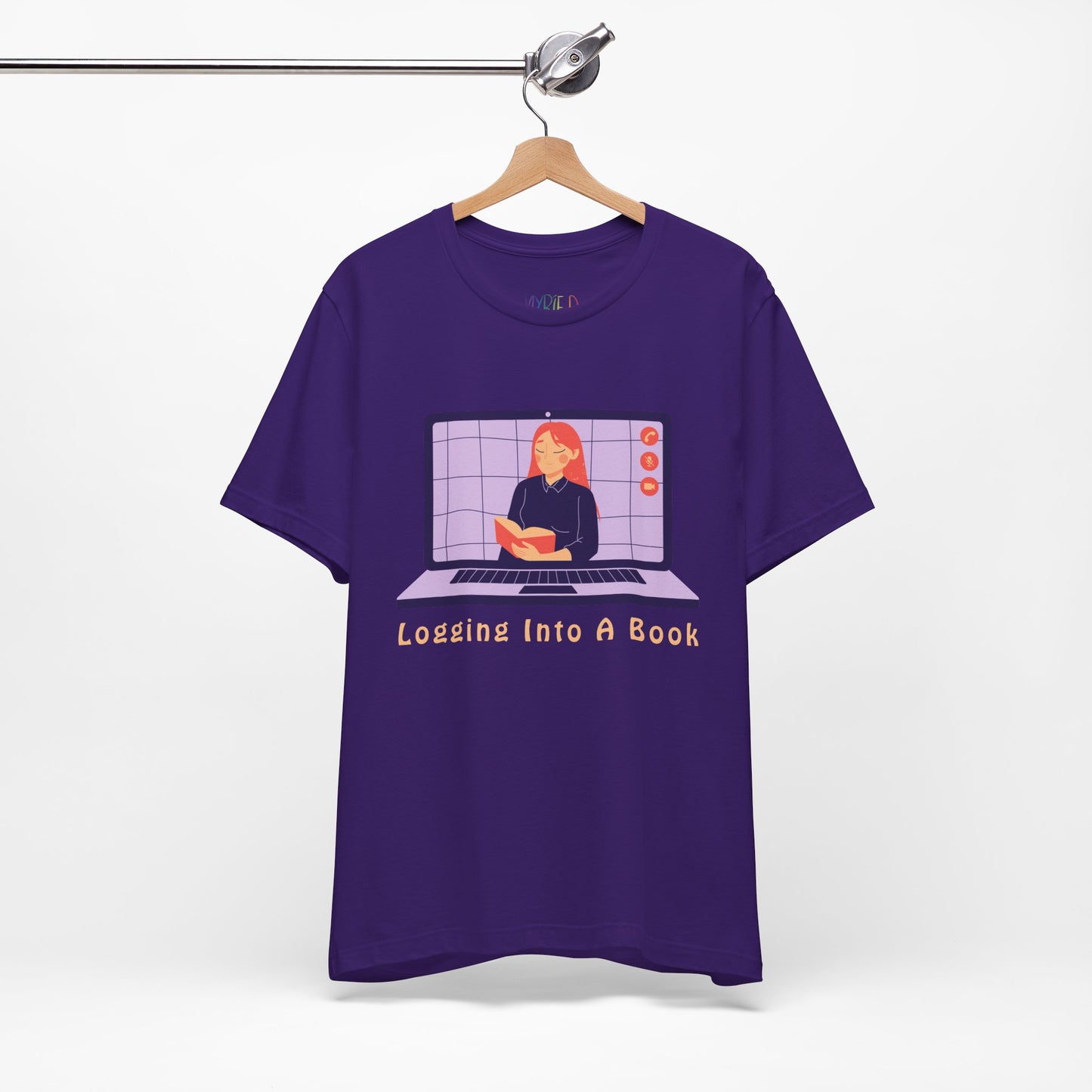 Purple t-shirt with open laptop featuring a woman reading a book and text 'Logging Into A Book' 