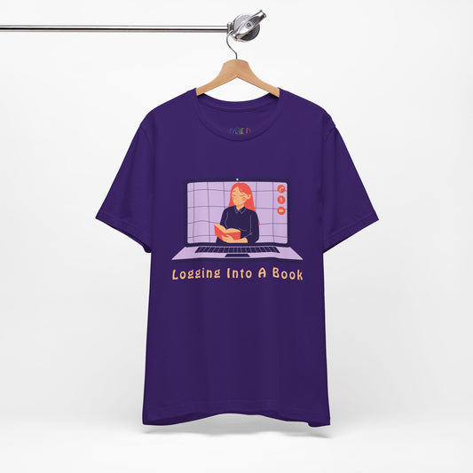 Purple t-shirt with open laptop featuring a woman reading a book and text 'Logging Into A Book' 