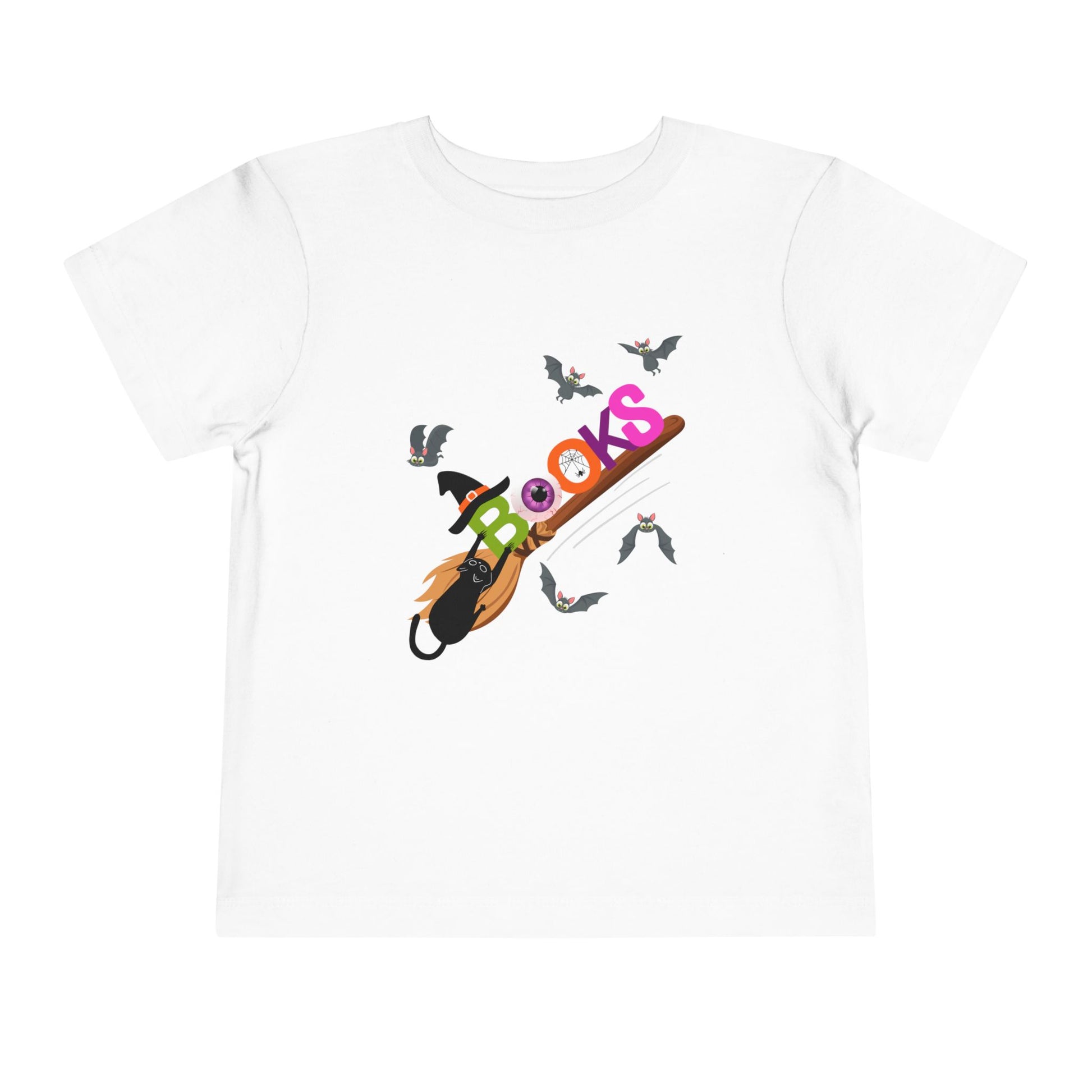 White toddler t-shirt with colorful graphic design of 'BOOKS' riding a broom with a black cat barely handing on and bats all around