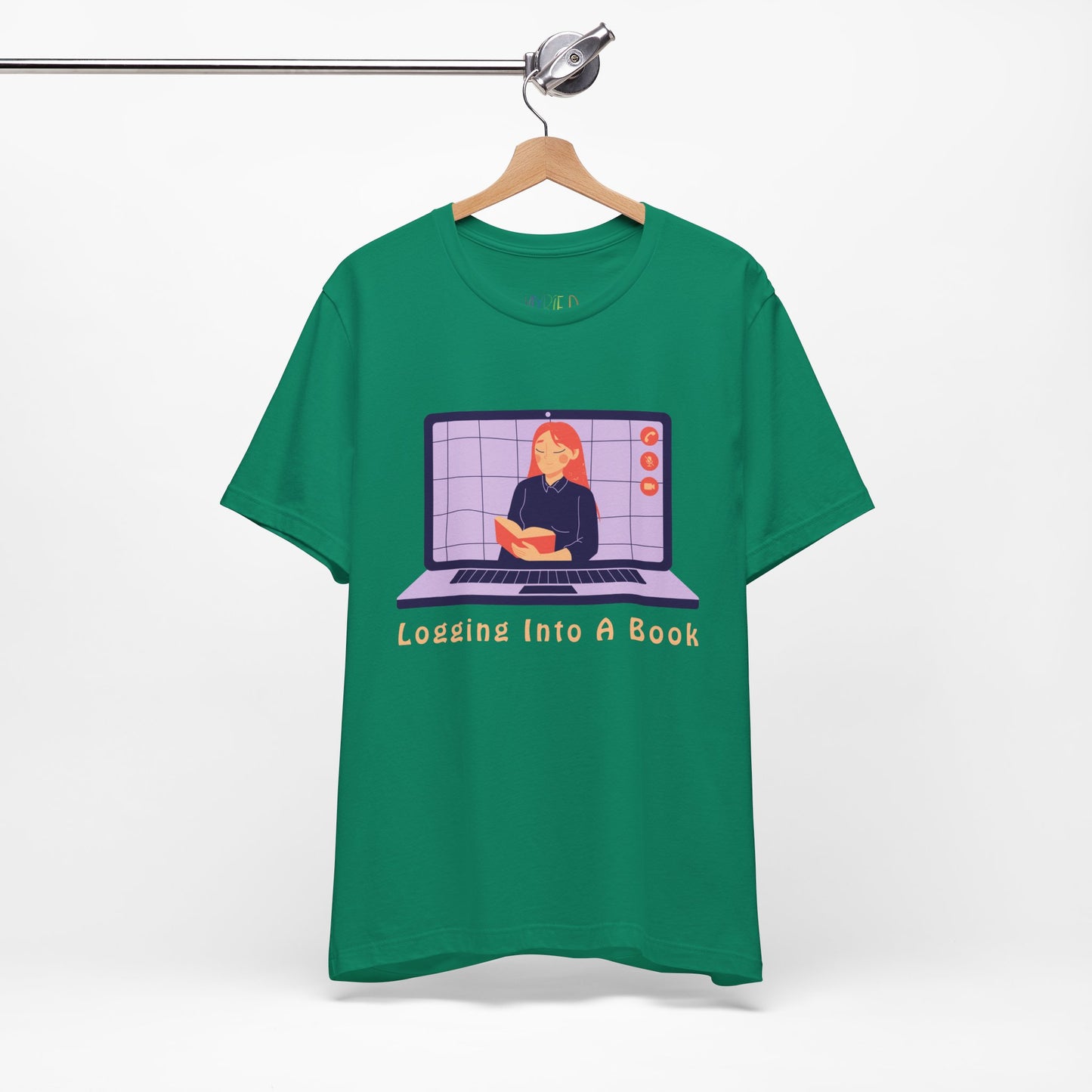 Green t-shirt with open laptop featuring a woman reading a book and text 'Logging Into A Book' 