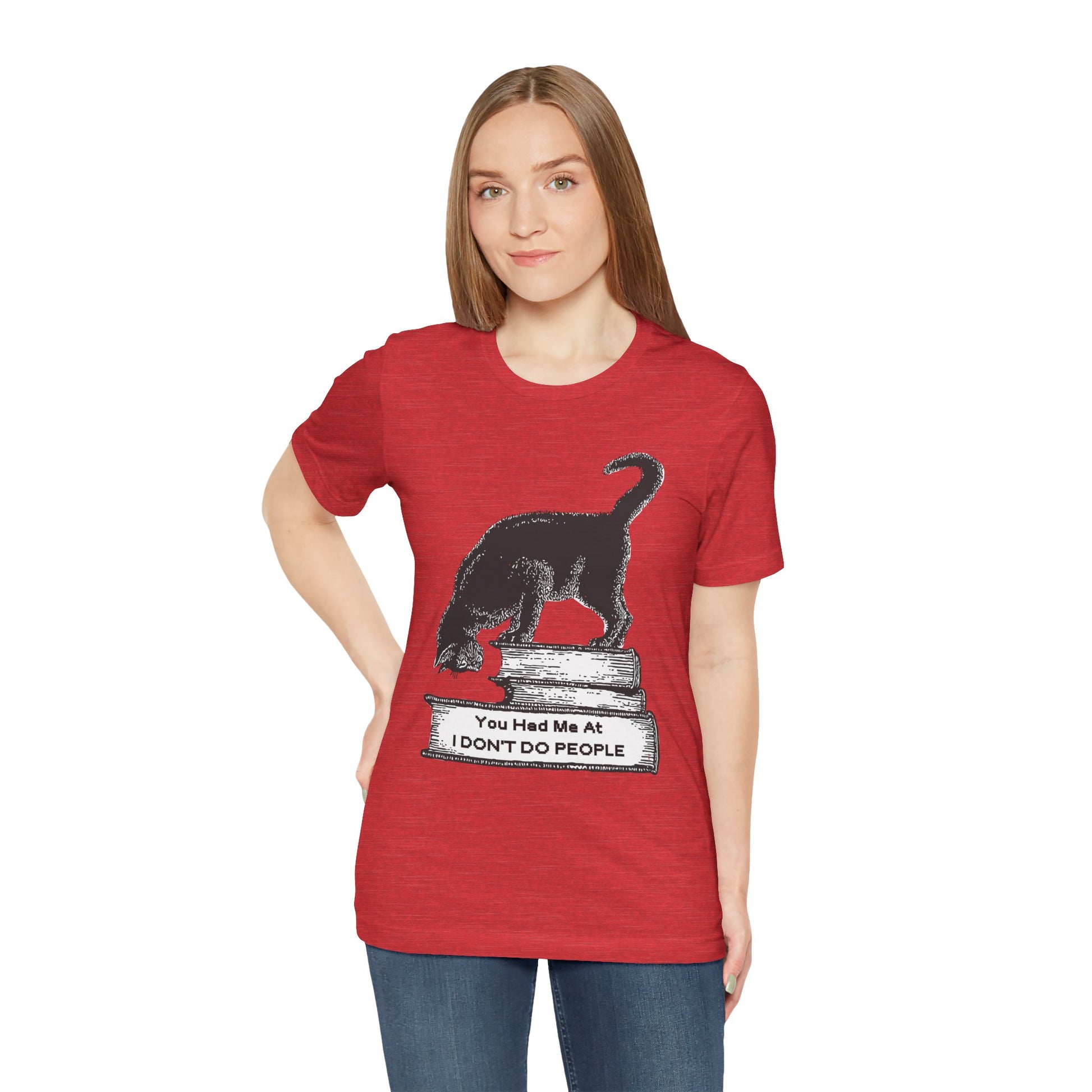 Woman wearing a red t-shirt with a graphic design of a cat on a stack of books and text 'You Had Me At I Don't Do People'