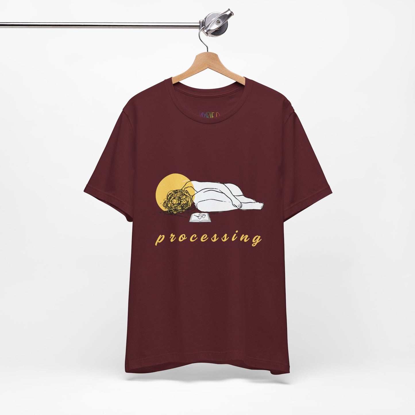 Maroon t-shirt with person laying in a heap next to a book and 'processing' text 