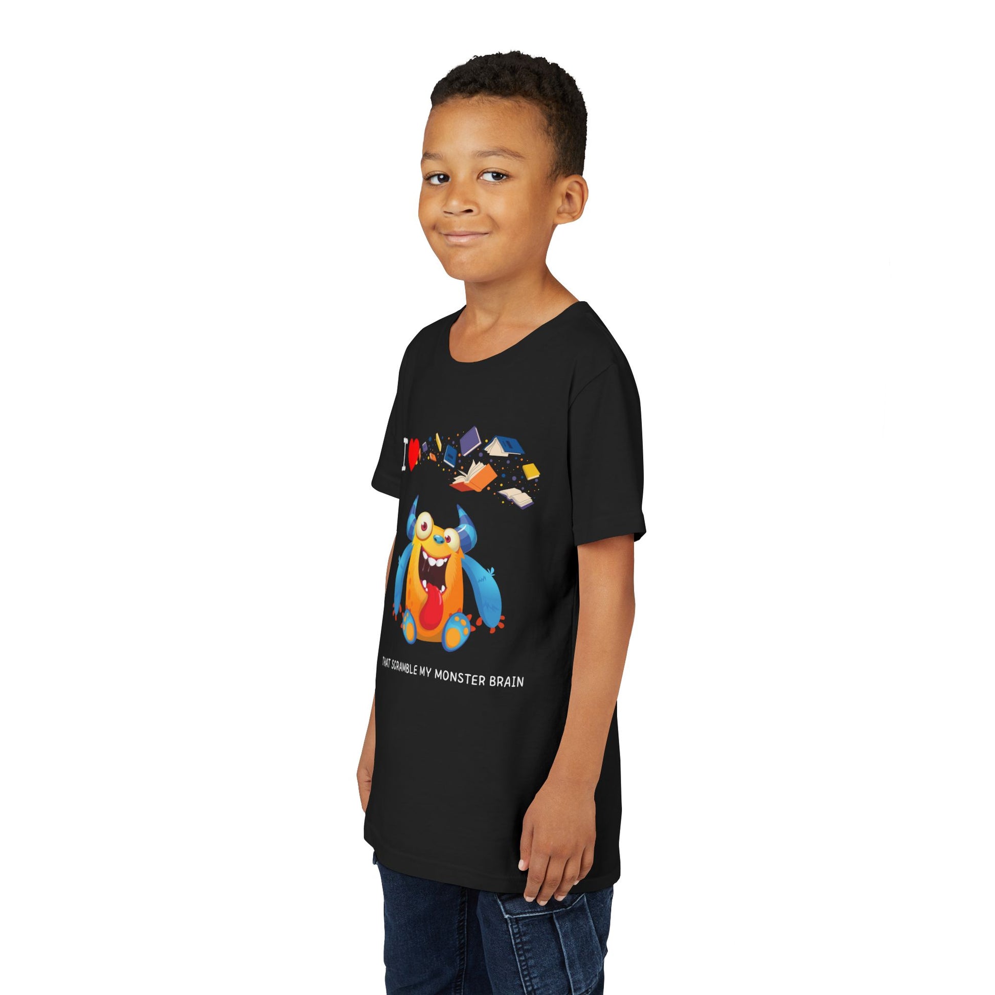 Boy wearing a black t-shirt with a goofy, yet colorful cartoon monster character, books flying through air and playful I love books that Scramble My Monster Brain text