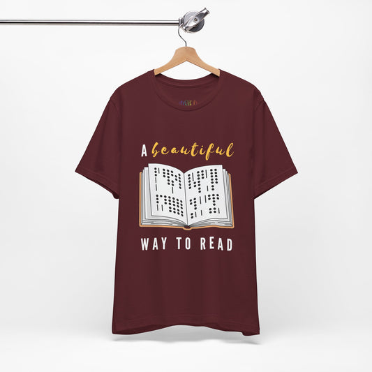 Maroon t-shirt with graphic design of a book in braille and text 'A Beautiful Way to Read'