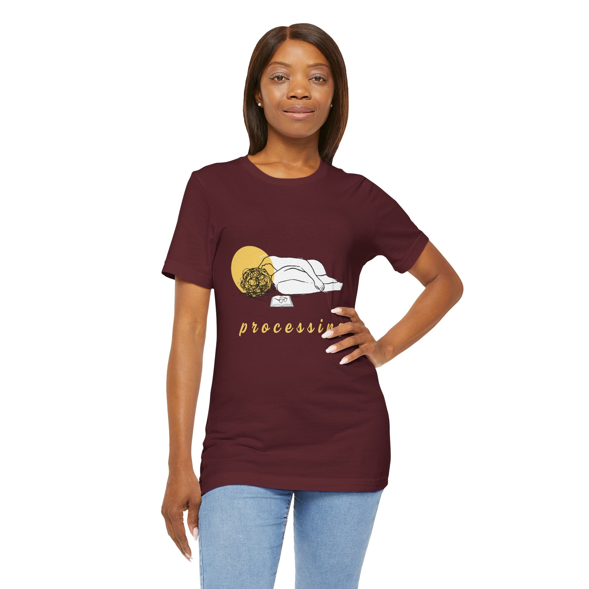 Woman wearing a maroon t-shirt with person laying in a heap next to a book and 'processing' text 