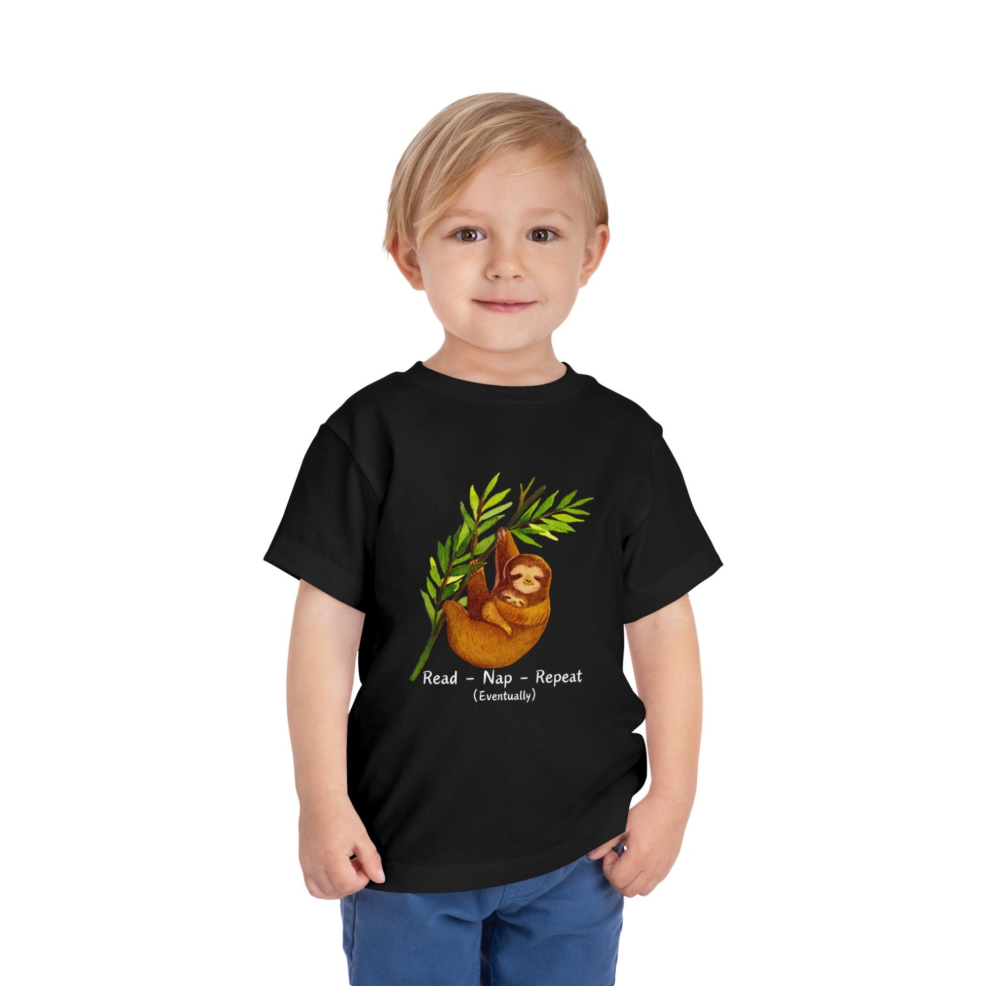 Child wearing a black toddler t-shirt with a mama and baby sloth, and text 'Read - Nap - Repeat (Eventually)' 