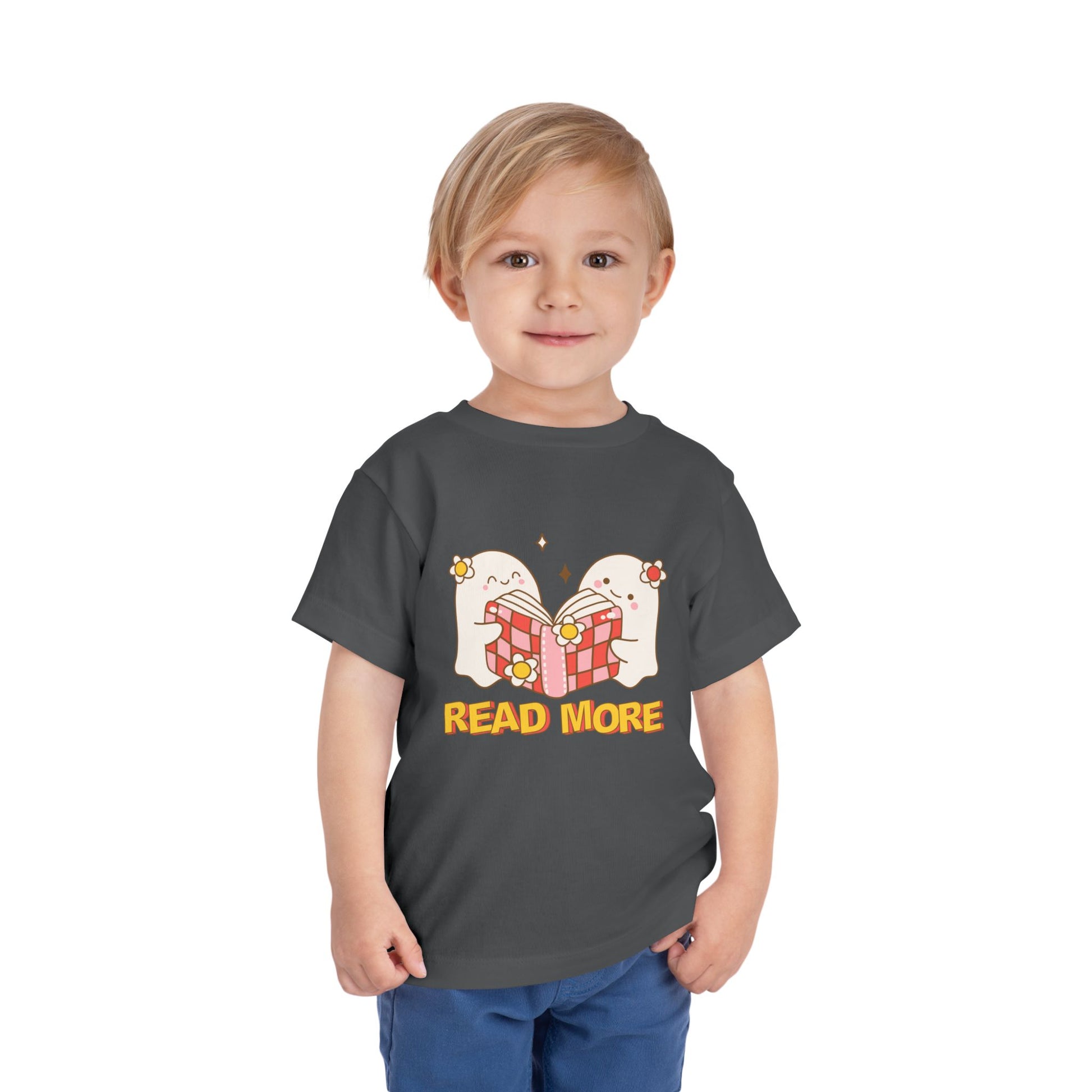 Toddler wearing a gray t-shirt with cartoon ghosts reading a shared book and 'Read More' text 