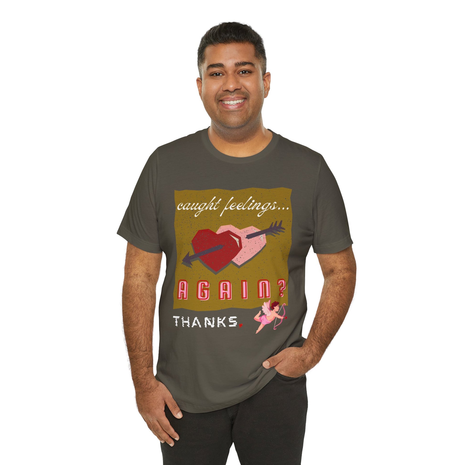 Man wearing a military green t-shirt with double heart graphic design and text 'Caught Feelings AGAIN? Thanks,' followed by a picture of cupid