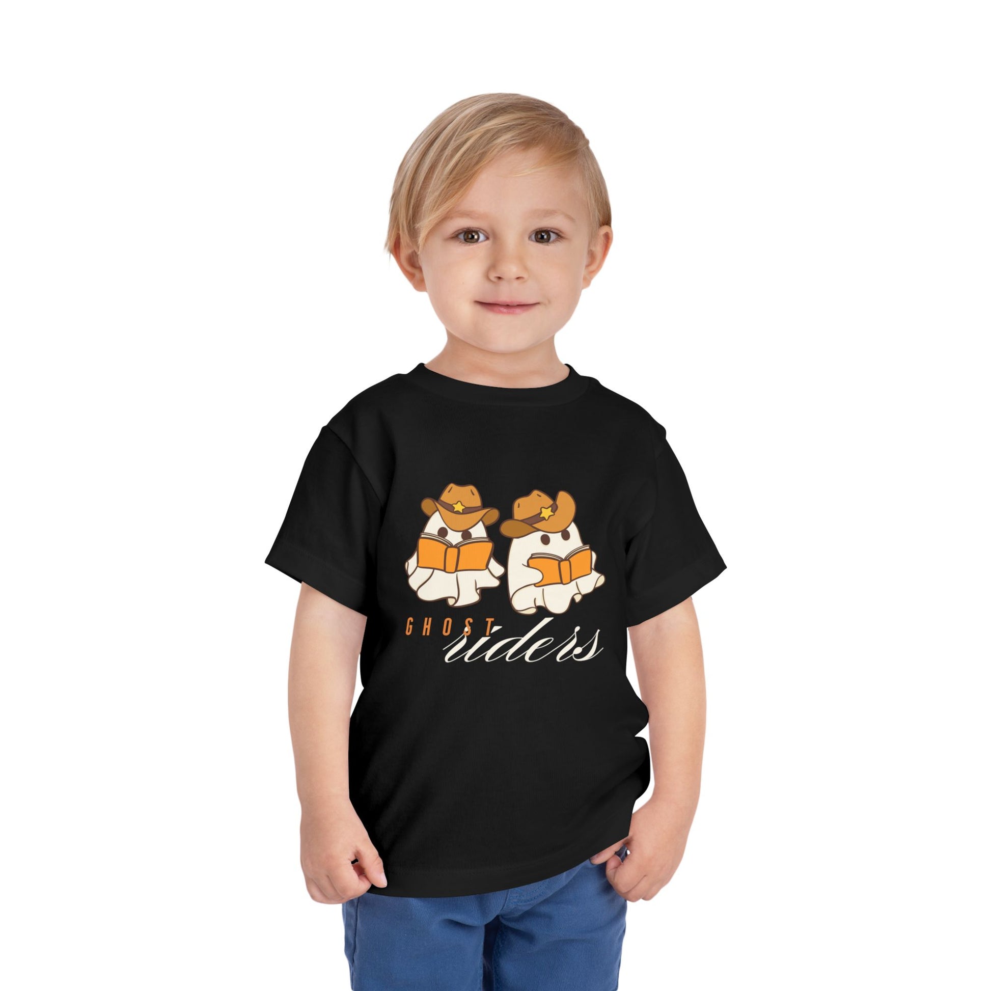 Toddler wearing a black t-shirt with two cowboy hat wearing ghosts reading books and text 'Ghost Riders' 