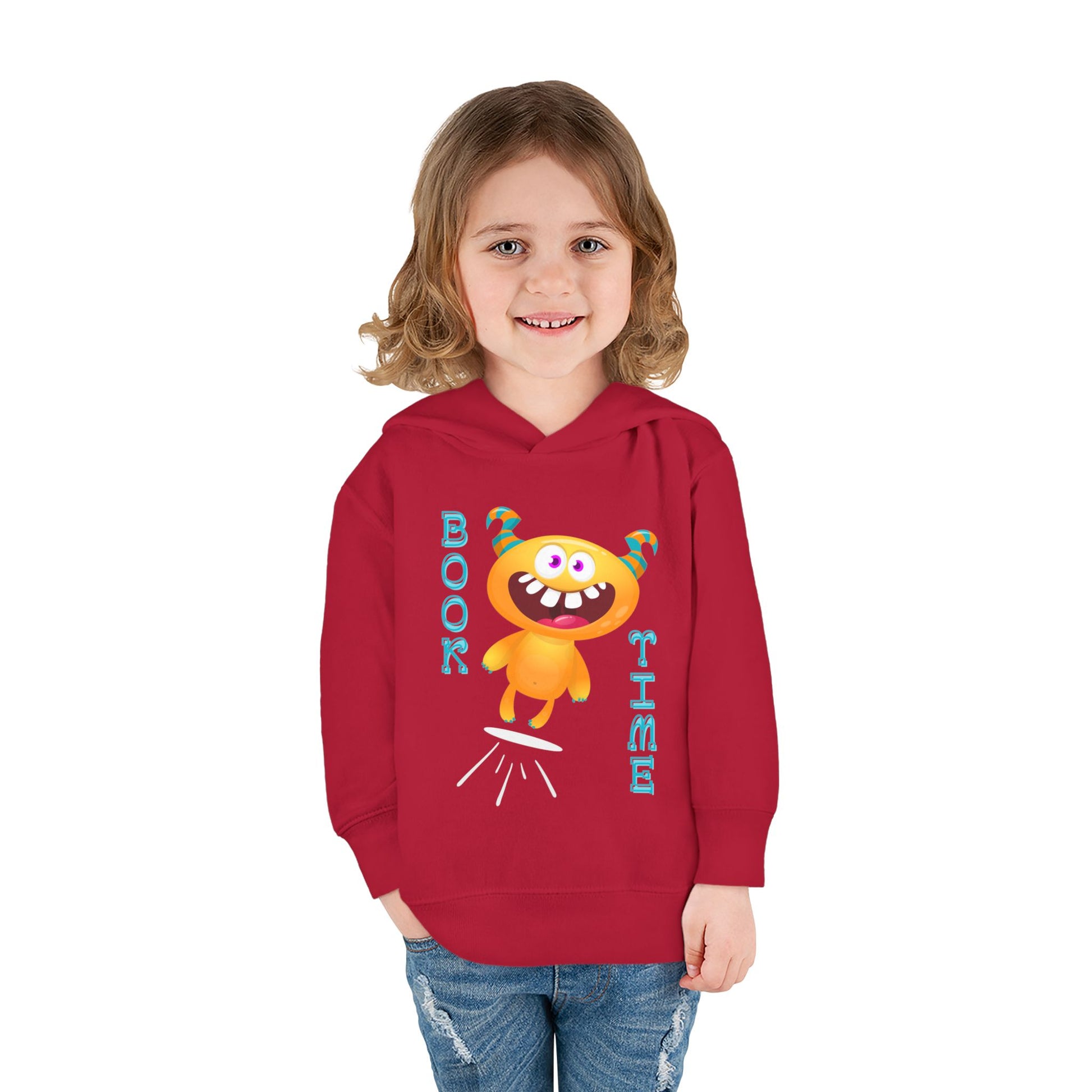 Girl wearing a red toddler hoodie with a cartoon monster jumping and text 'BOOK TIME'