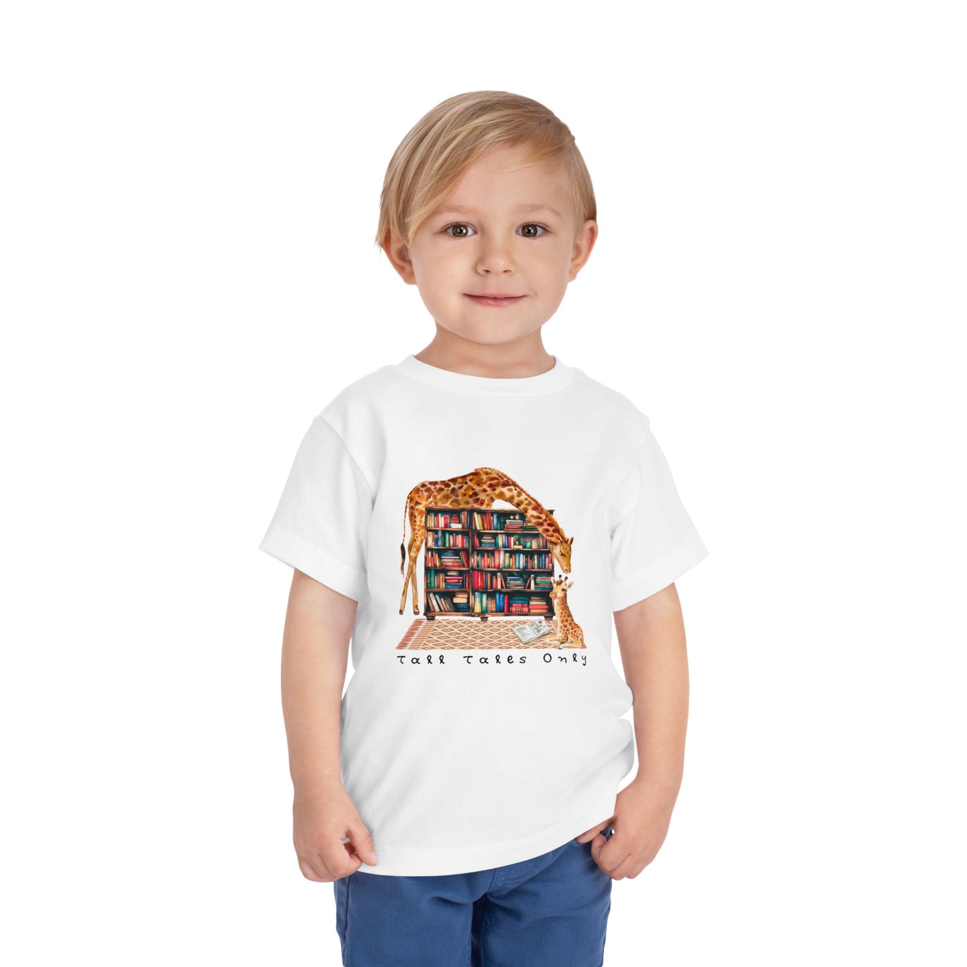 Child wearing a white toddler t-shirt with a mama giraffe leaning over library bookshelves to check on her little one and text 'Tall Tales Only'