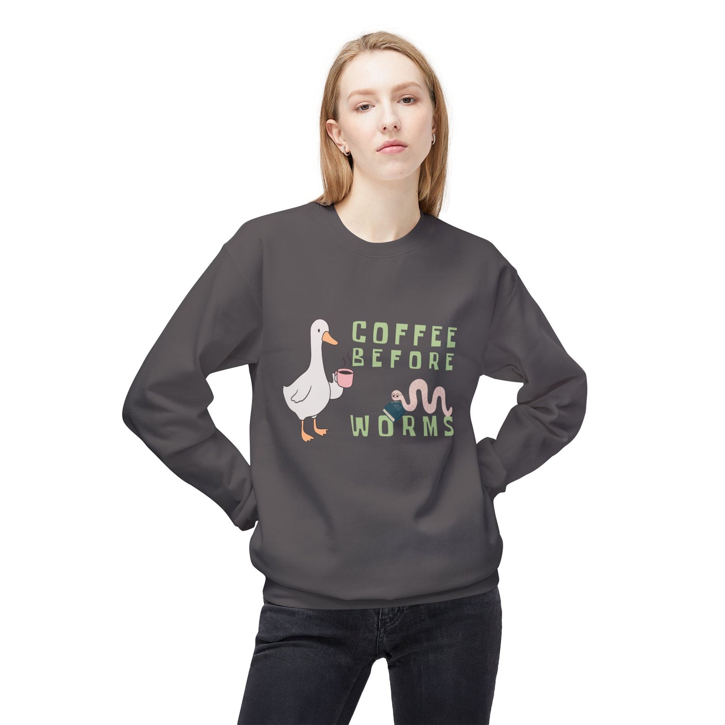 Woman wearing a gray sweatshirt with a graphic of a duck holding a coffee cup and text 'Coffee Before Worms' 