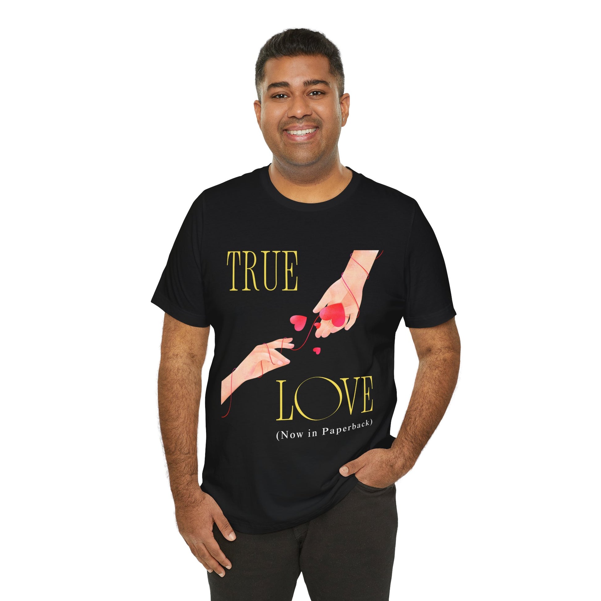 Man wearing a black t-shirt with 'True Love (Now in Paperback)' text and graphic of two hands reaching foreach other, entwined in red string and hearts