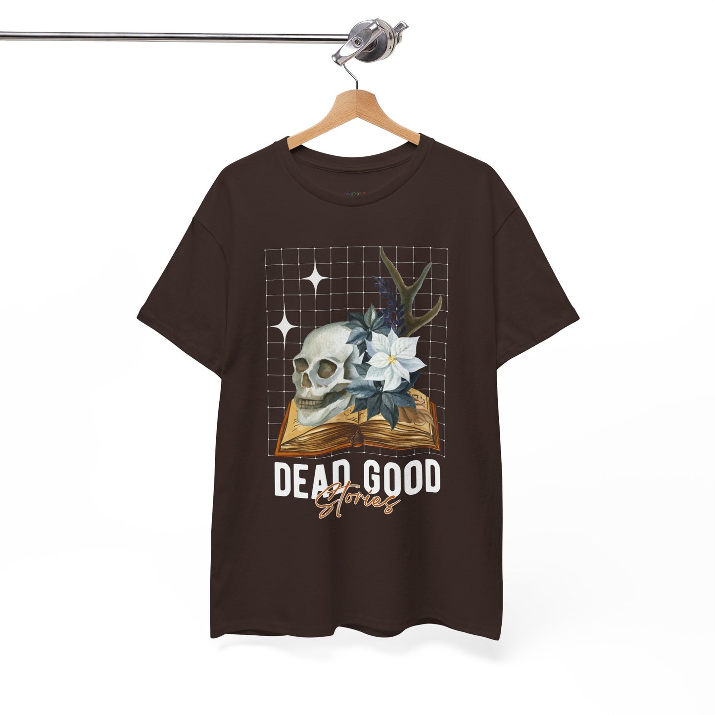 Brown t-shirt with skull, antler, and flower on a book with text 'Dead Good Stories' on a hanger against a white background