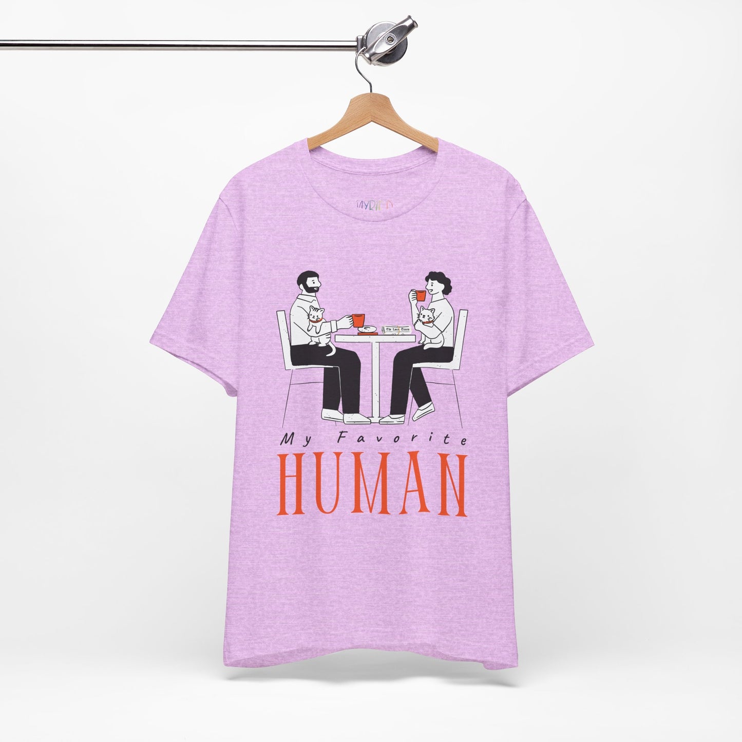 Purple t-shirt with a graphic of two people sitting at a table, newspaper in front of one, drinking hot beverages, holding cats and text 'My Favorite Human' 