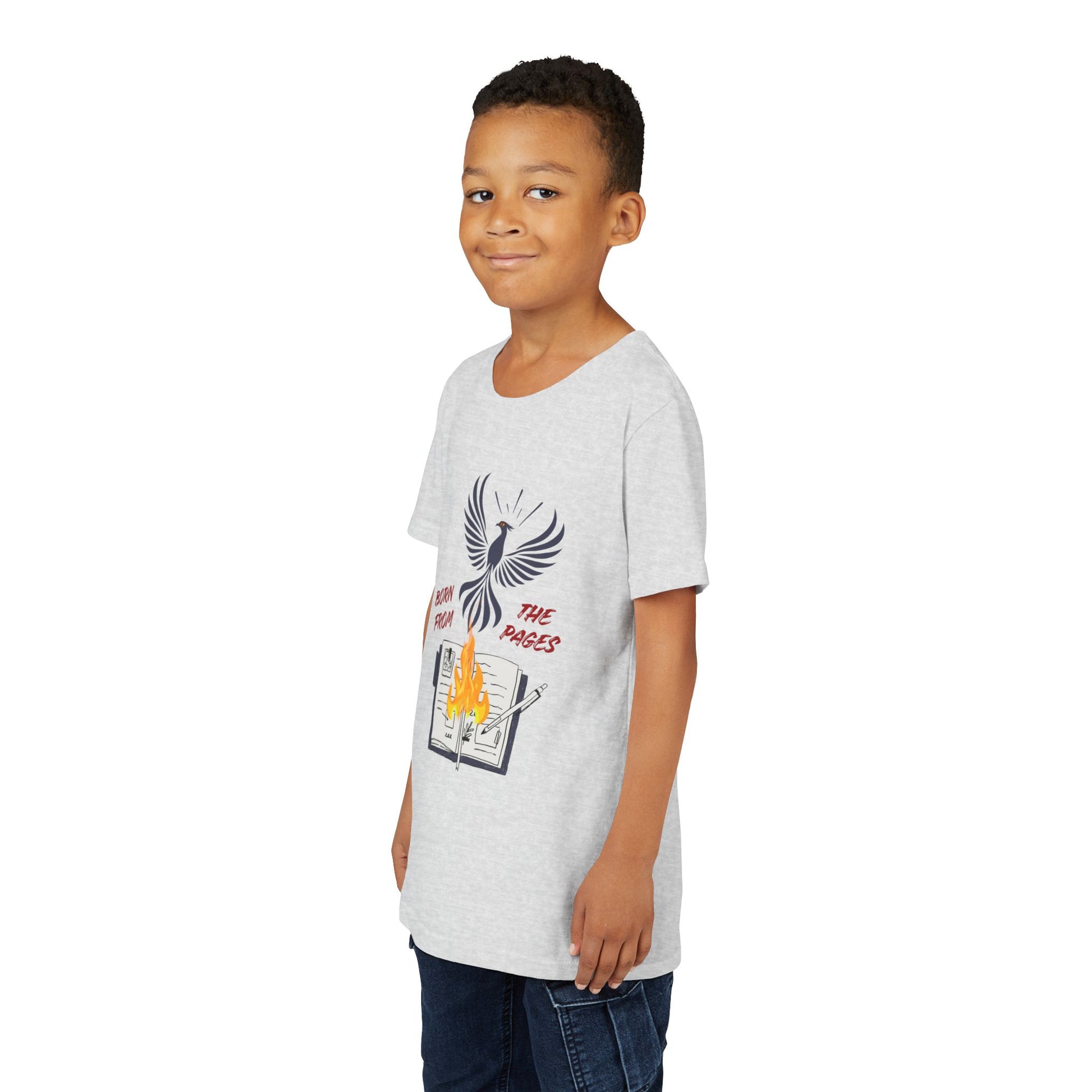 Boy wearing a light ash gray t-shirt with a graphic design featuring a phoenix rising from burning pages and text 'Born From The Pages'
