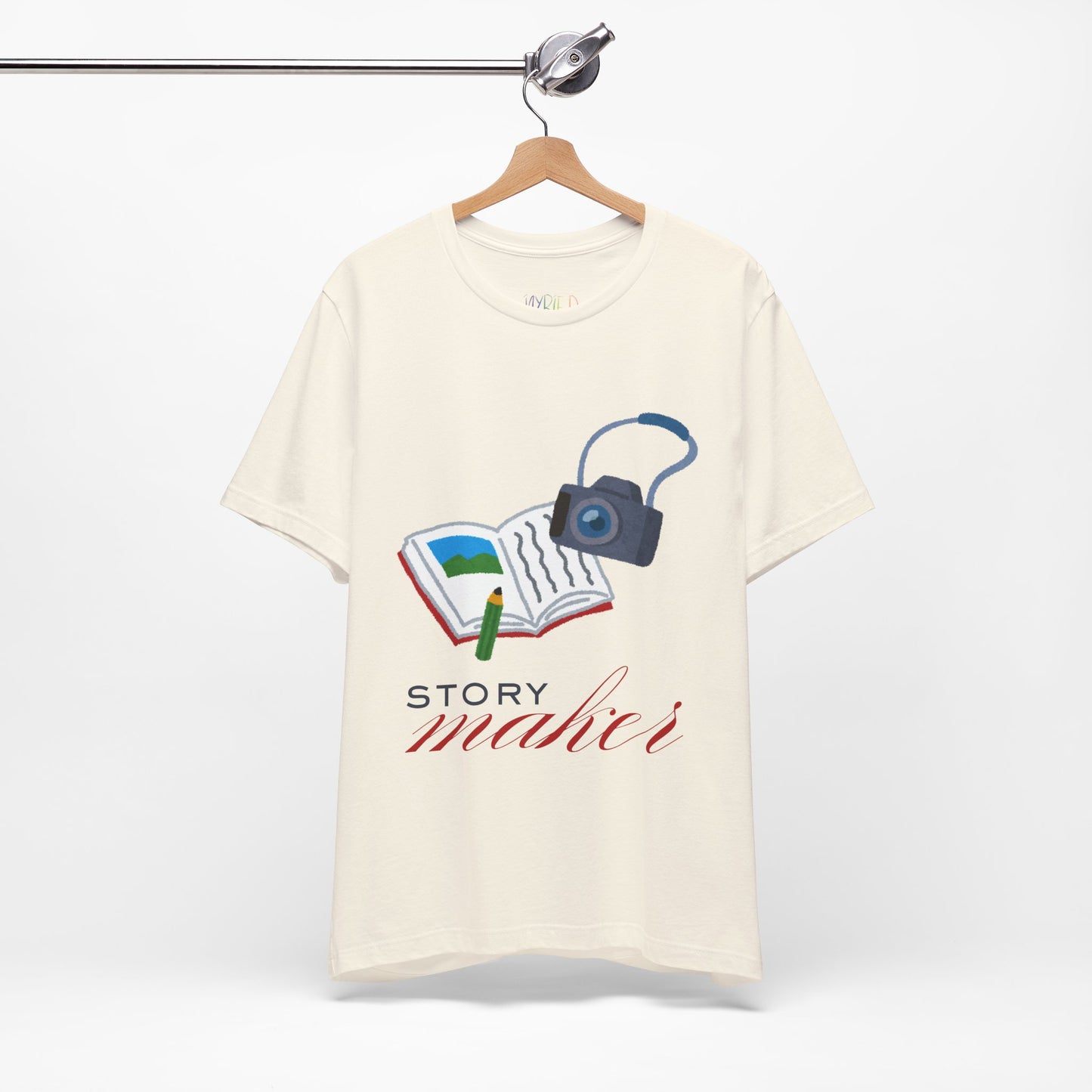 Beige t-shirt with an open book, pencil and camera, 'Story Maker' text beneath