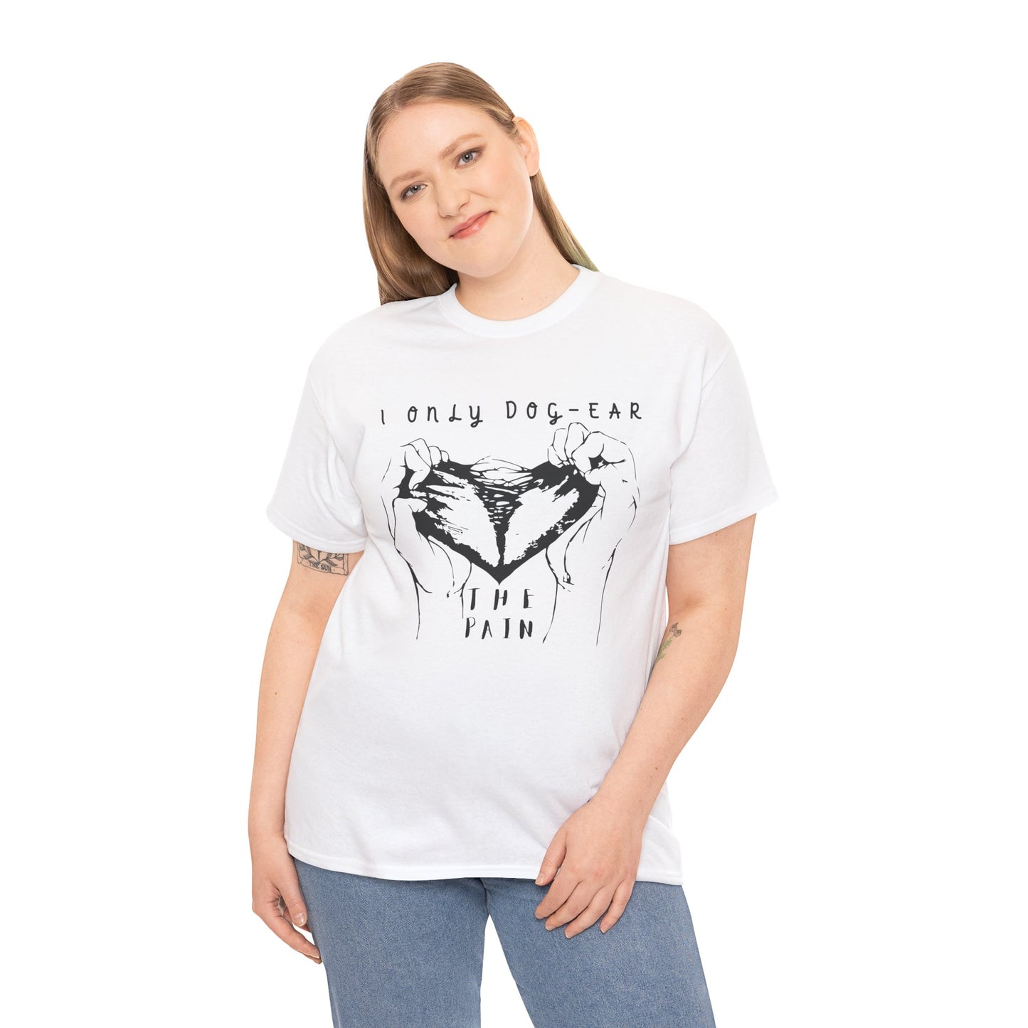 Woman wearing a white t-shirt with black graphic of hands tearing apart a heart and text 'I Only Dog-Ear The Pain'