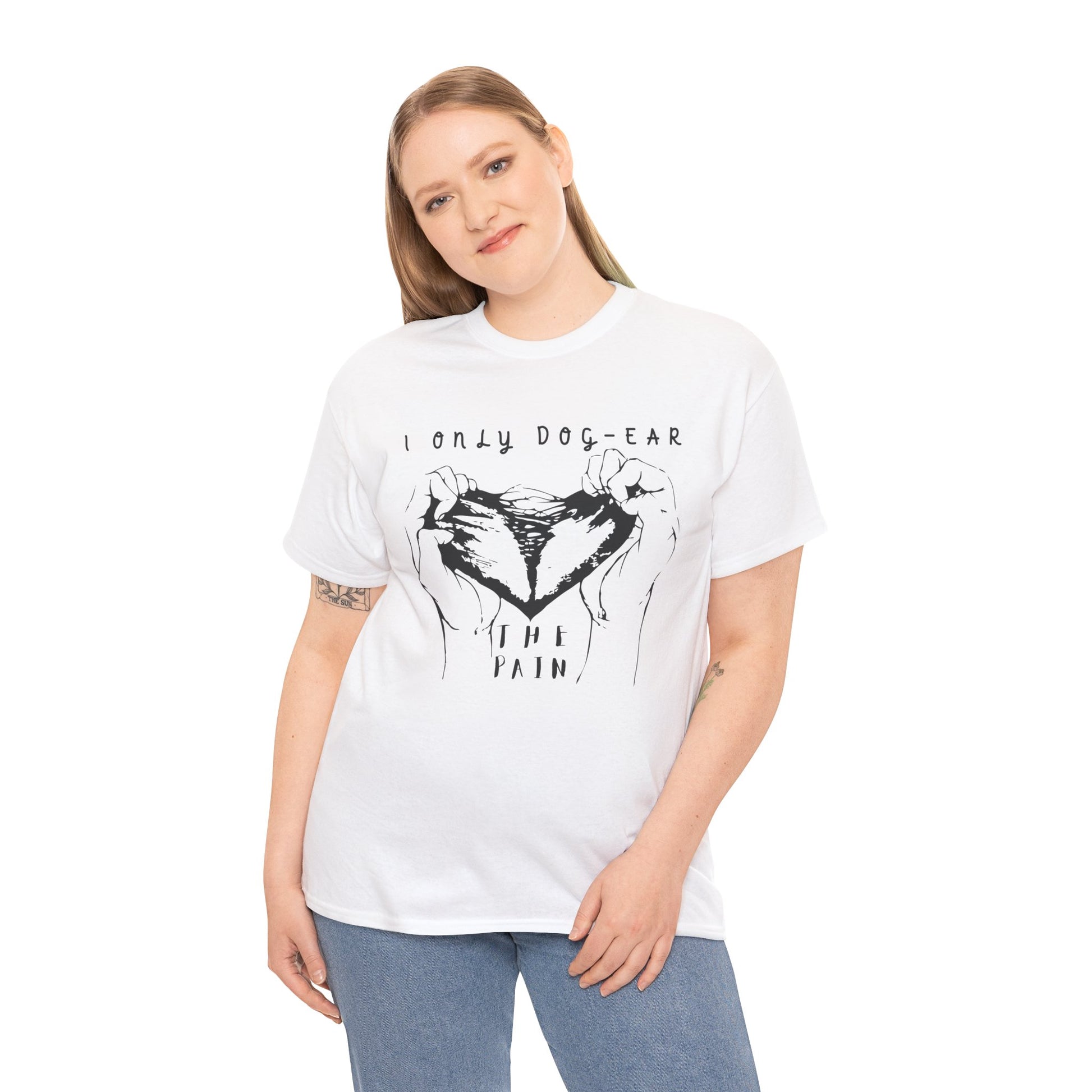 Woman wearing a white t-shirt with black graphic of hands tearing apart a heart and text 'I Only Dog-Ear The Pain'