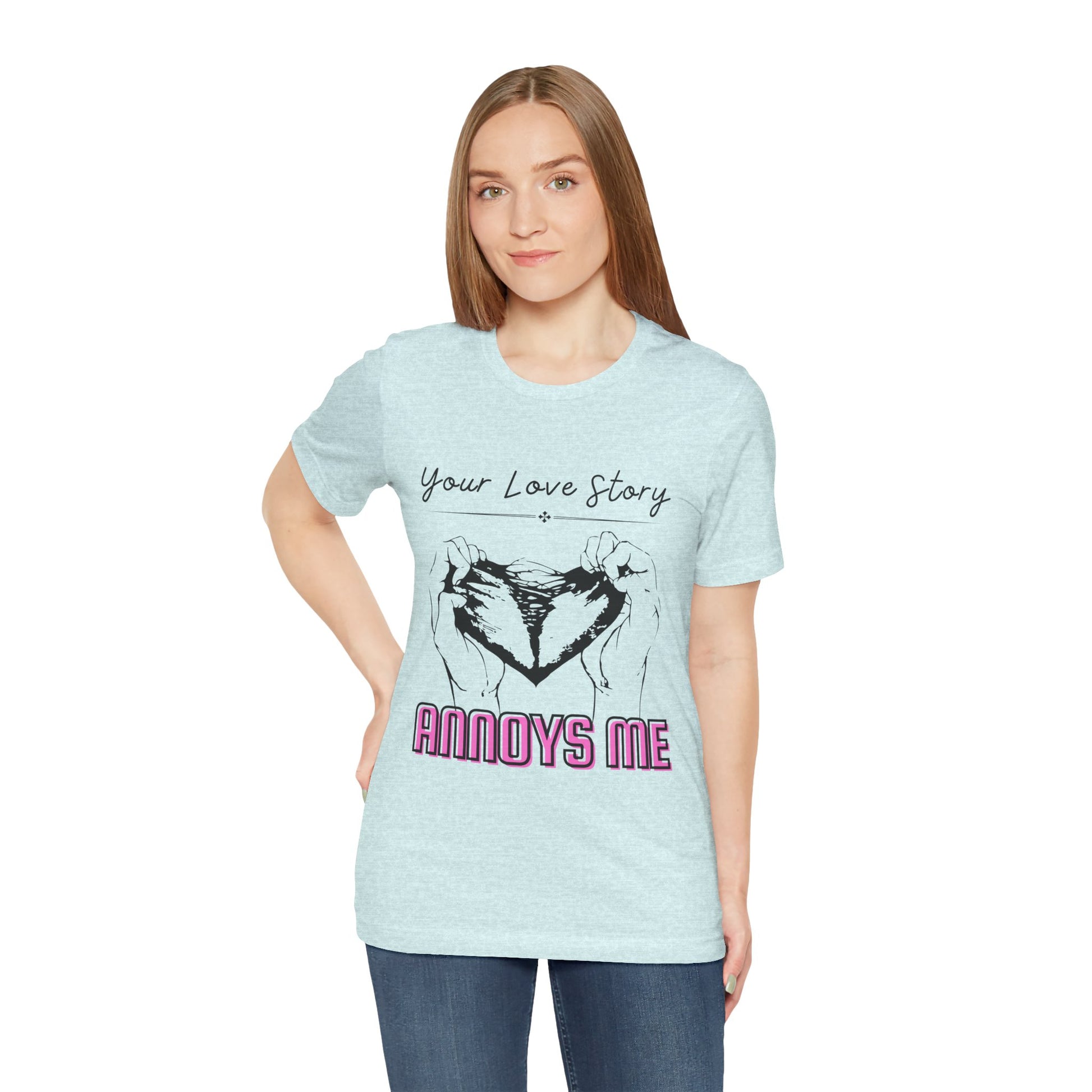 Woman wearing an icy blue t-shirt with graphic design of two hands pulling apart a heart and text 'Your Love Story ANNOYS ME'
