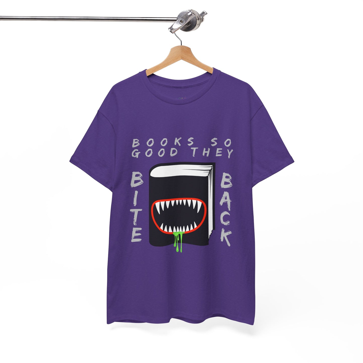 Purple t-shirt with a graphic design of a book with a drooling monster mouth and text 'Books So Good They Bite Back' on a hanger against a white background