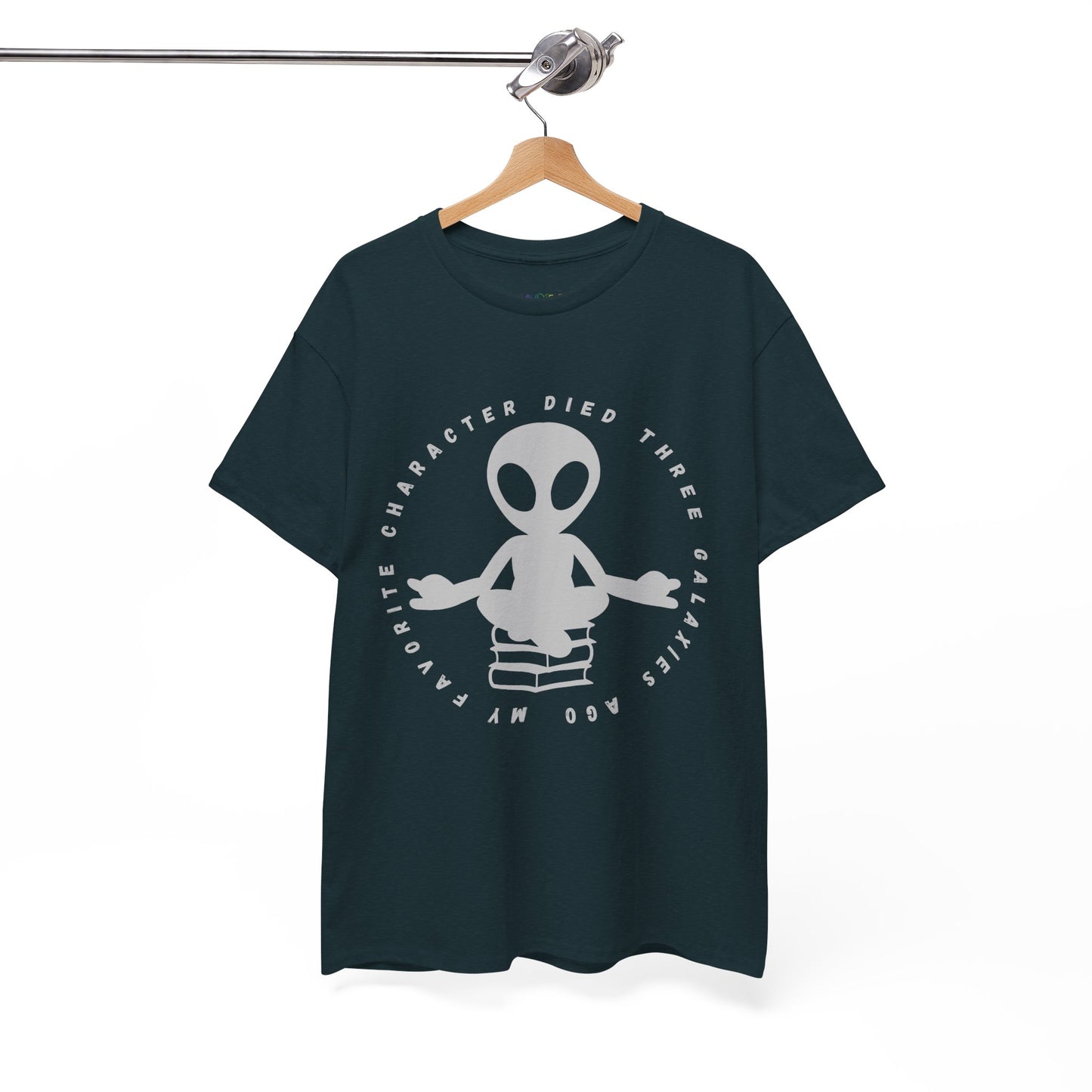 Dark t-shirt with meditating alien sitting on a stack of books, circled by text 'My Favorite Character Died Three Galaxies Ago' 