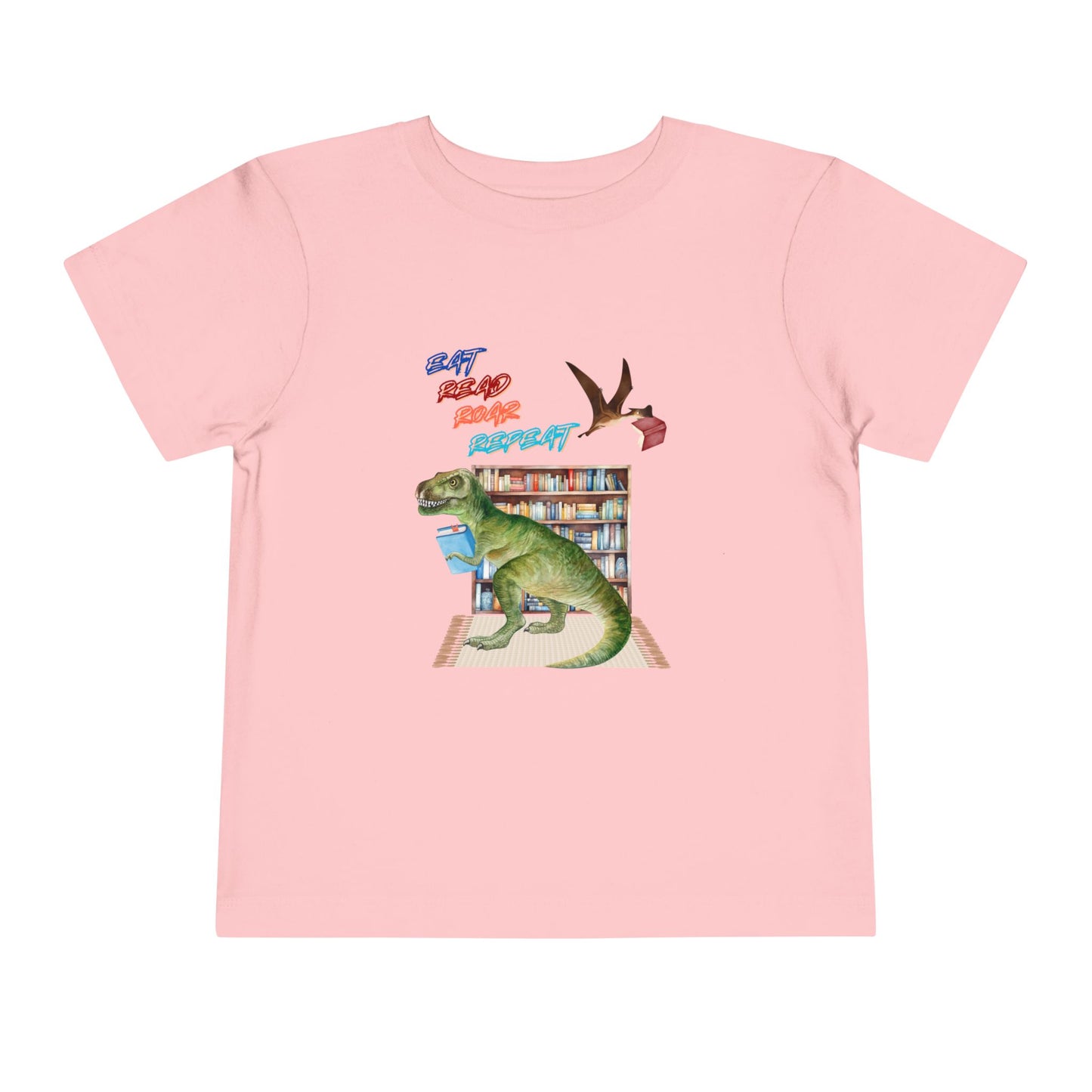 Pink toddler t-shirt with a t-rex dinosaur checking out a book at the library, a tera dactyl flying overhead with a book and text 'Eat, Read, Roar, Repeat' 