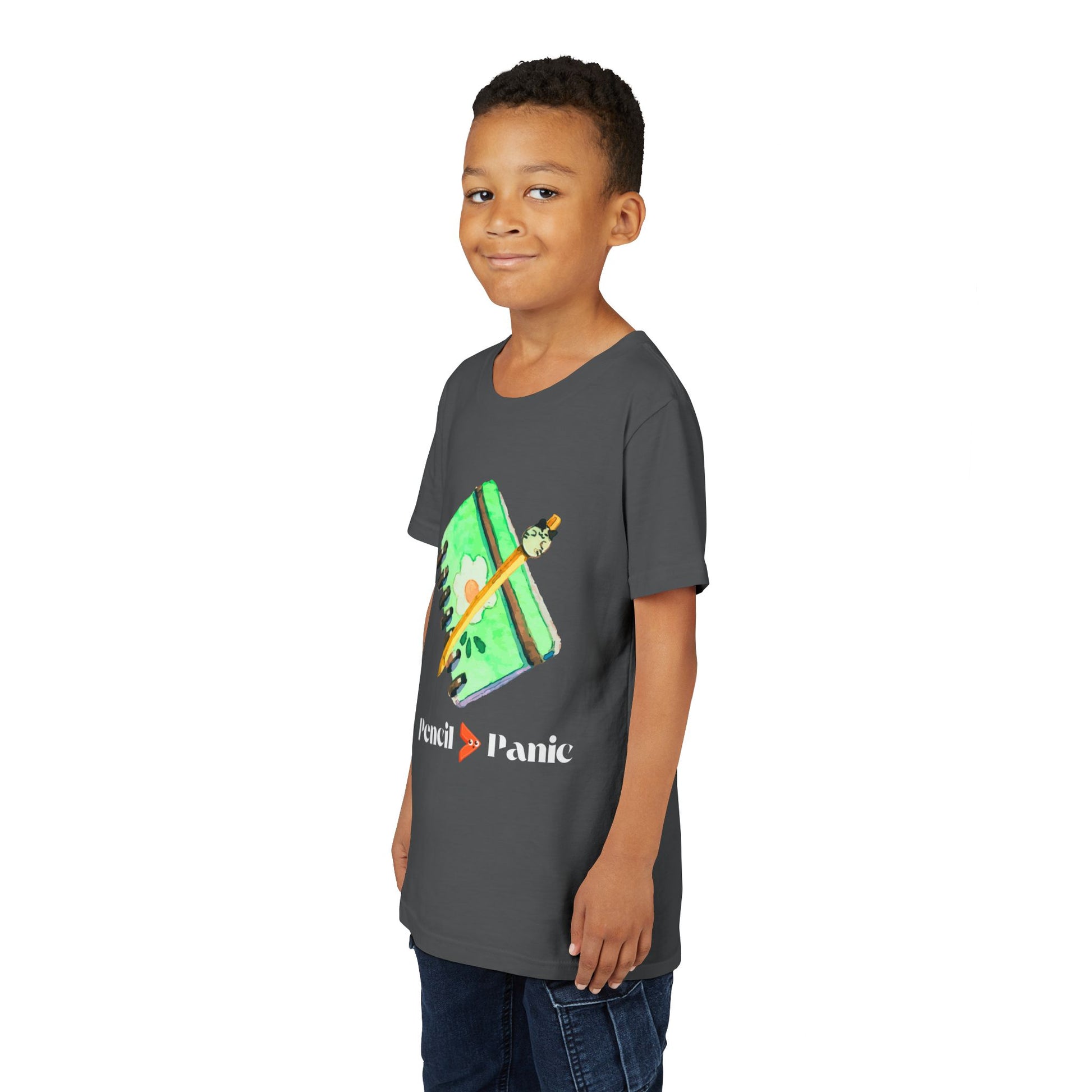 Boy wearing a gray t-shirt with a green notebook and pencil graphic and 'Pencil > Panic' text
