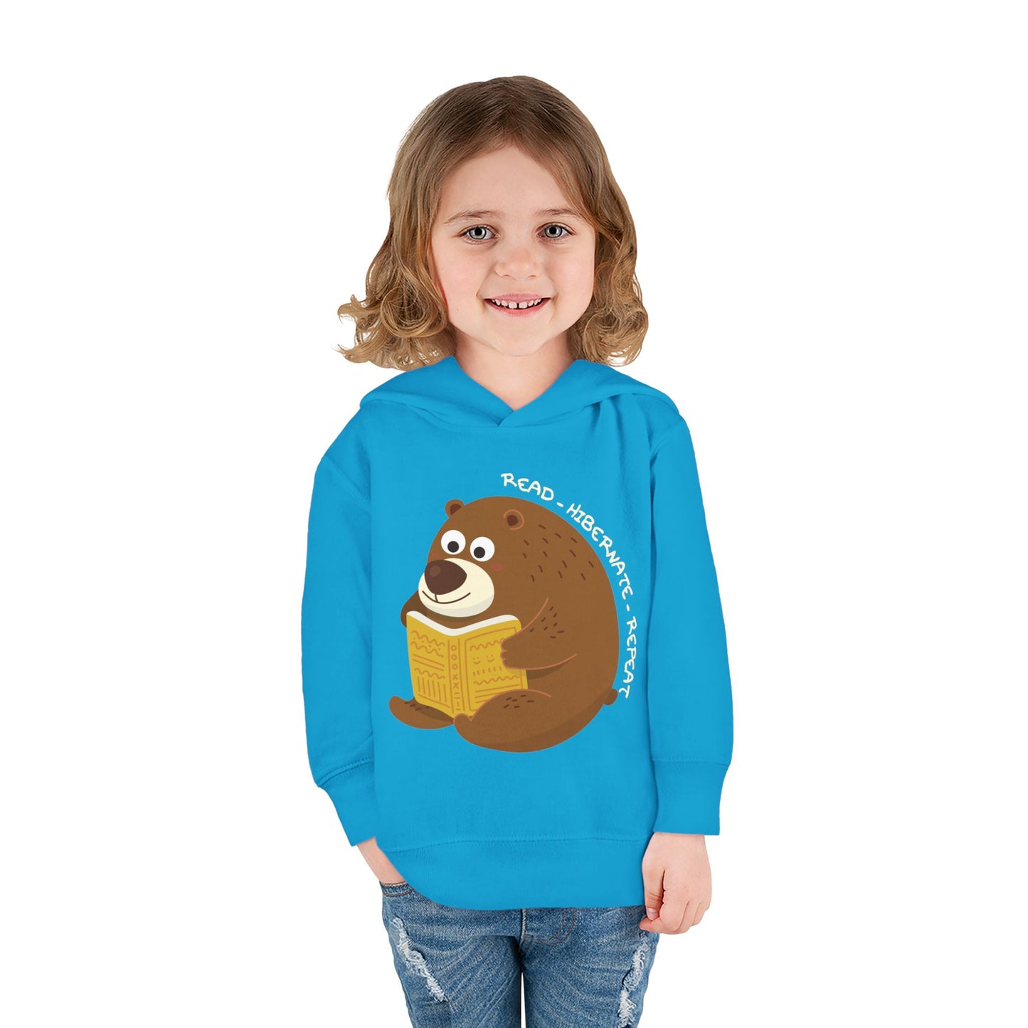 Girl wearing a turquoise toddler hoodie with a bear reading a book graphic and text 'Read, Hibernate, Repeat'