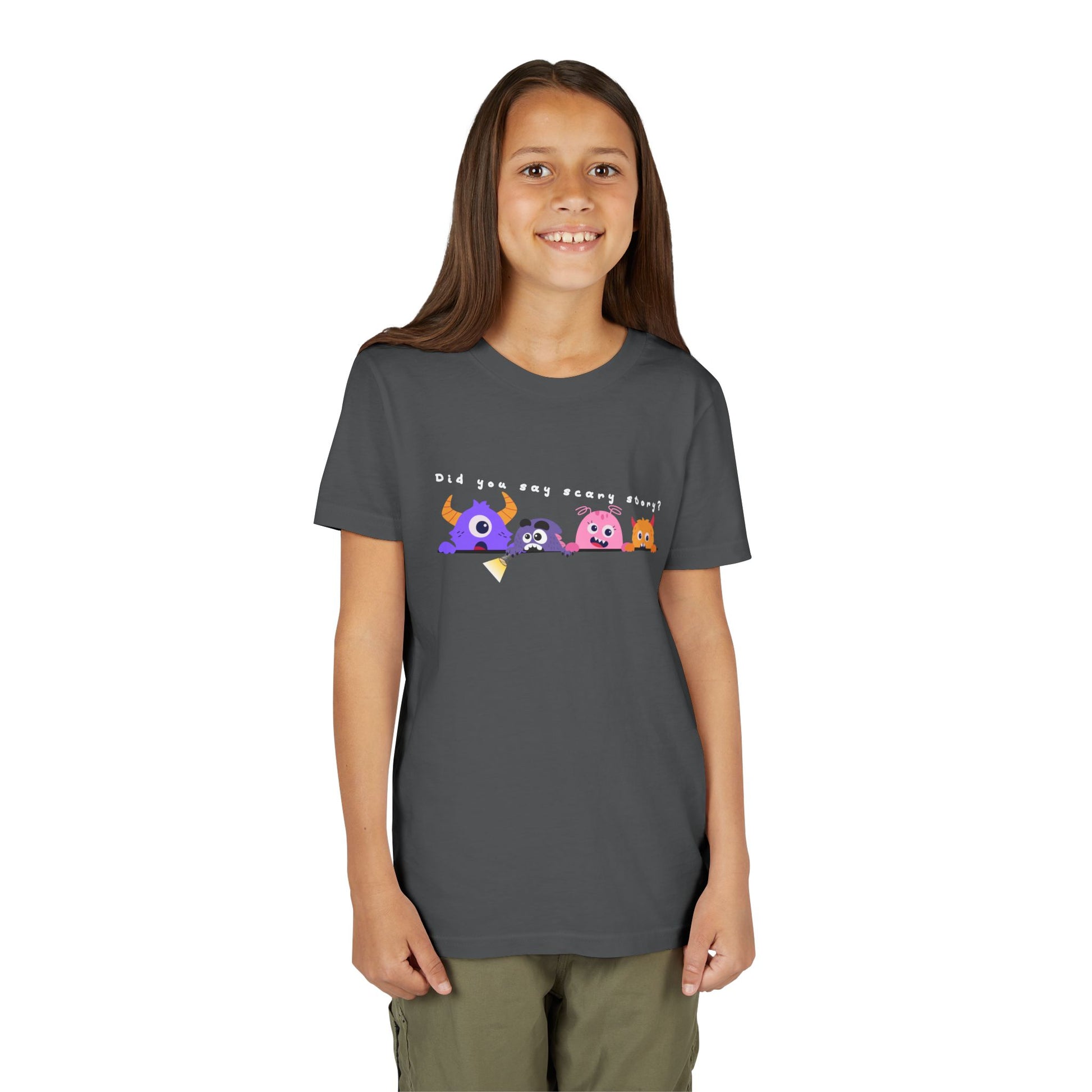 Girl wearing a gray t-shirt with a row of worried colorful cartoon monsters peaking over the edge of a line and text 'Did You Say Scary Story?' 