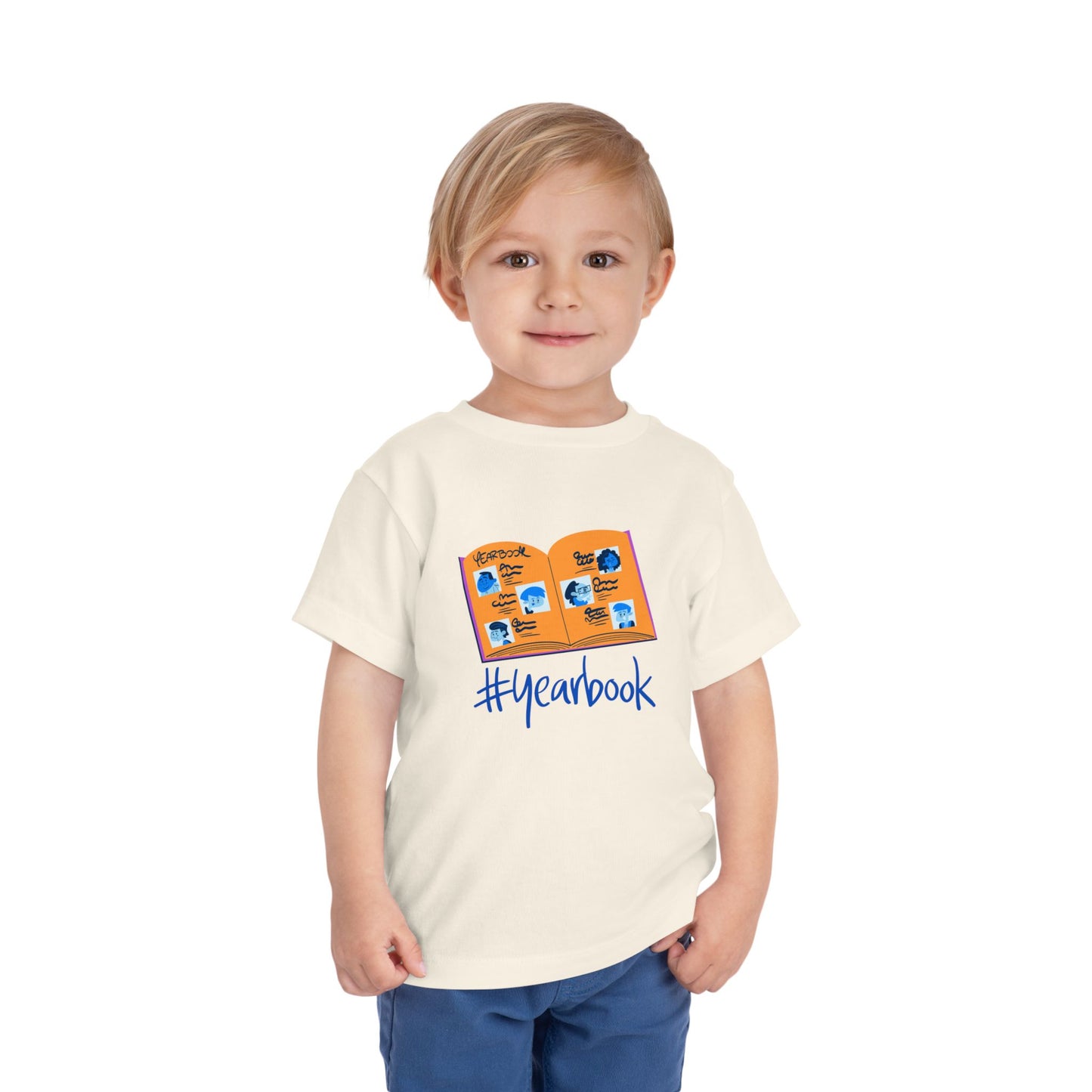 Toddler wearing a beige t-shirt with an open yearbook and '#yearbook' text