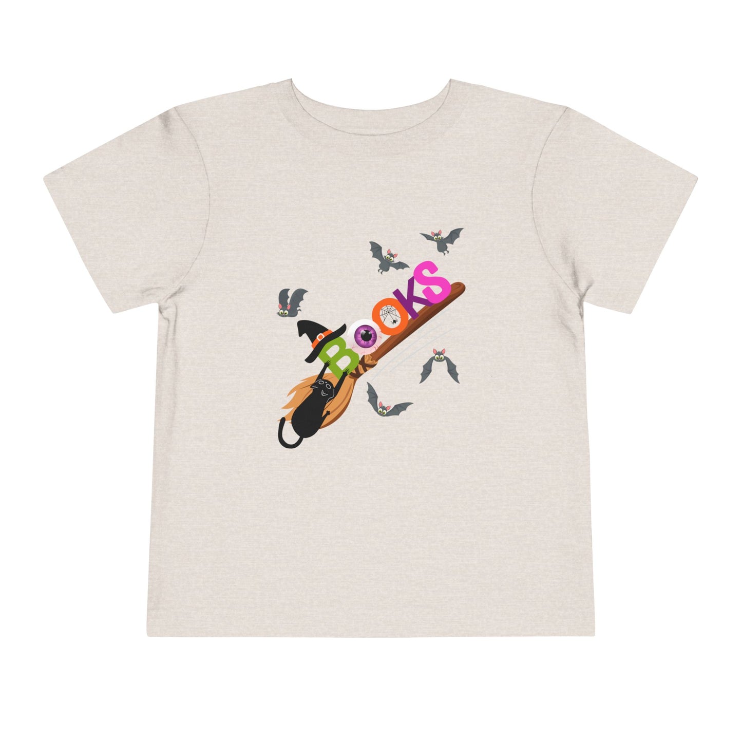 Beige toddler t-shirt with colorful graphic design of 'BOOKS' riding a broom with a black cat barely handing on and bats all around
