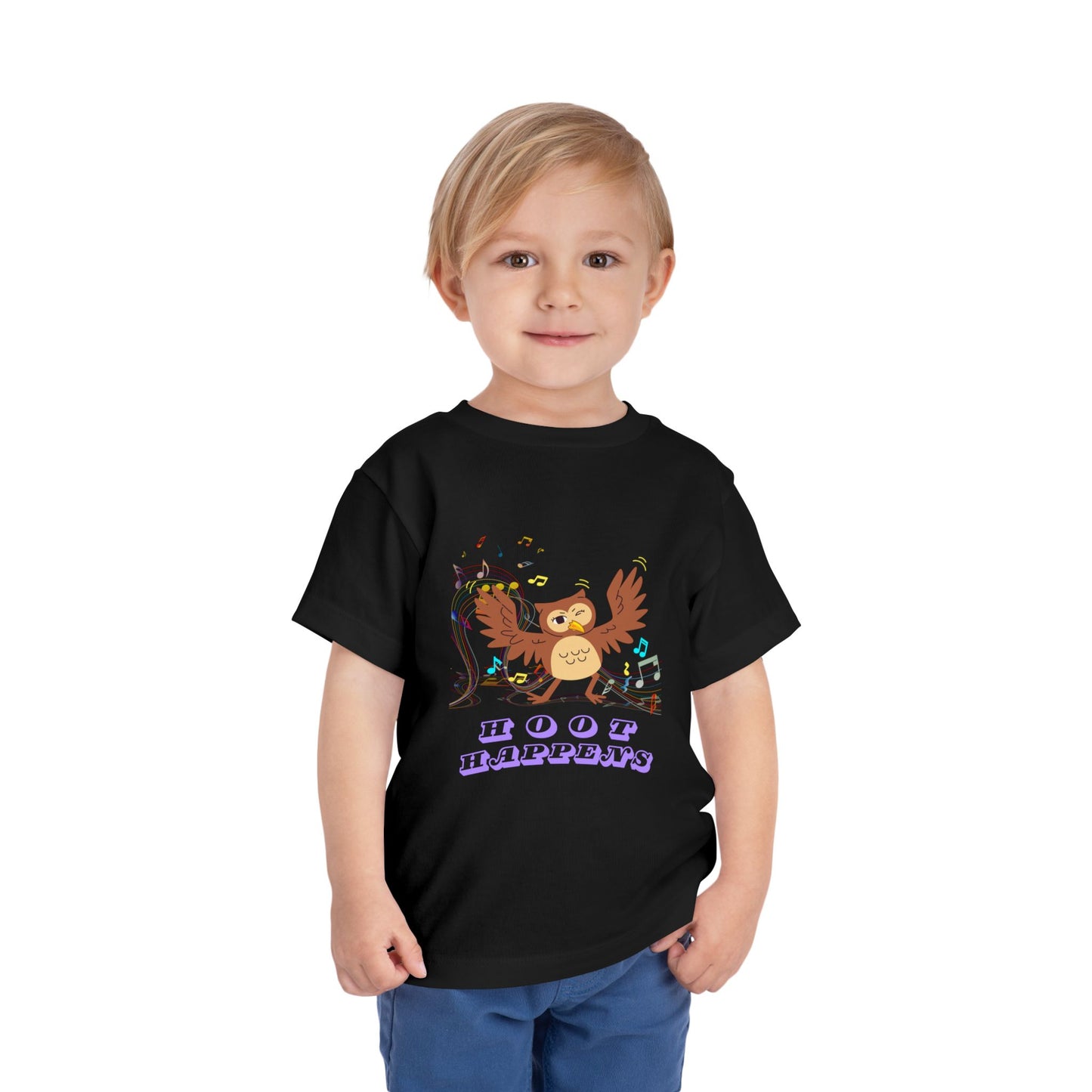 Child wearing a black toddler t-shirt with a colorful music notes and a dancing owl, 'Hoot happens' text 