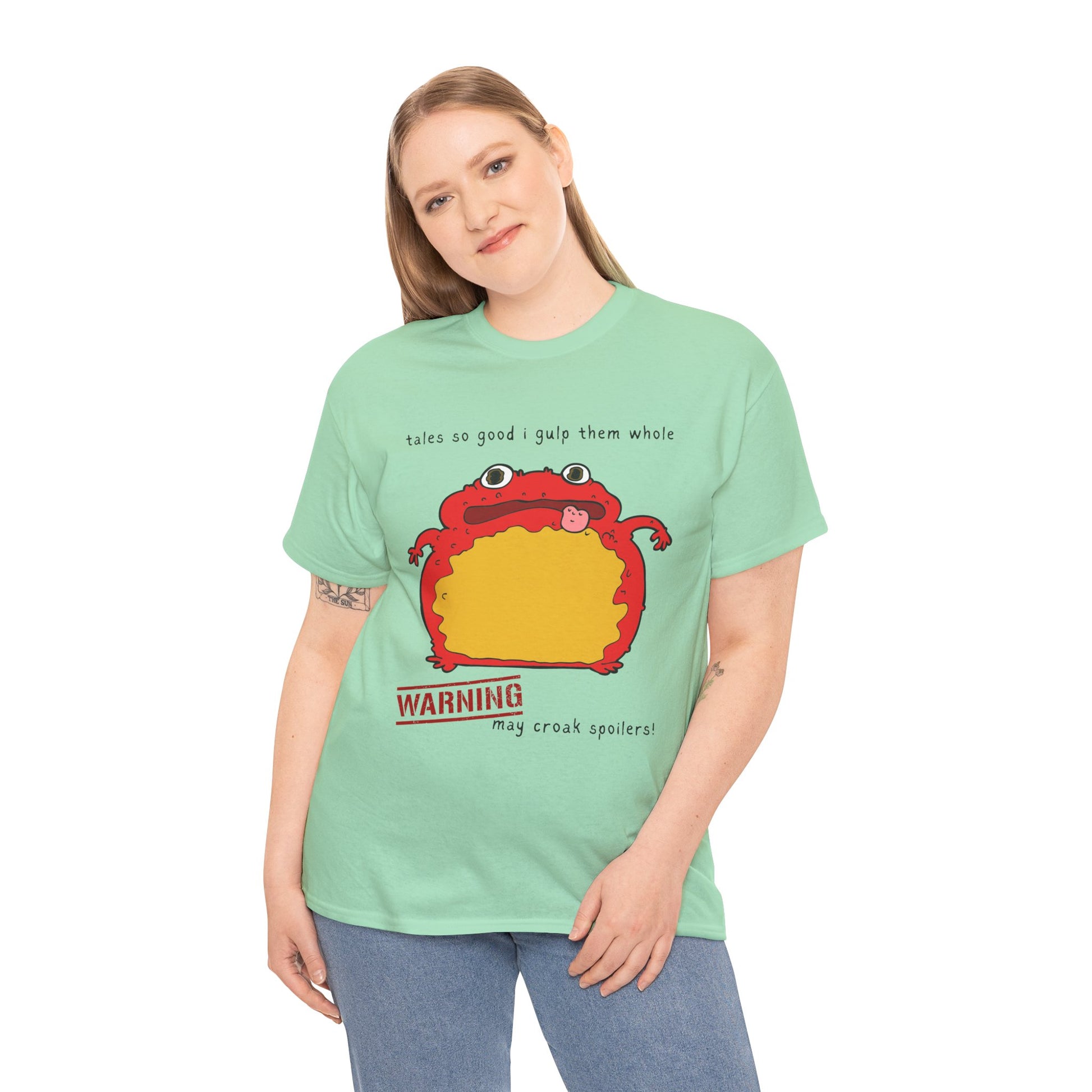 Woman wearing a light green t-shirt with a red toad and text 'tales so good I gulp them whole' and 'WARNING may croak spoilers'
