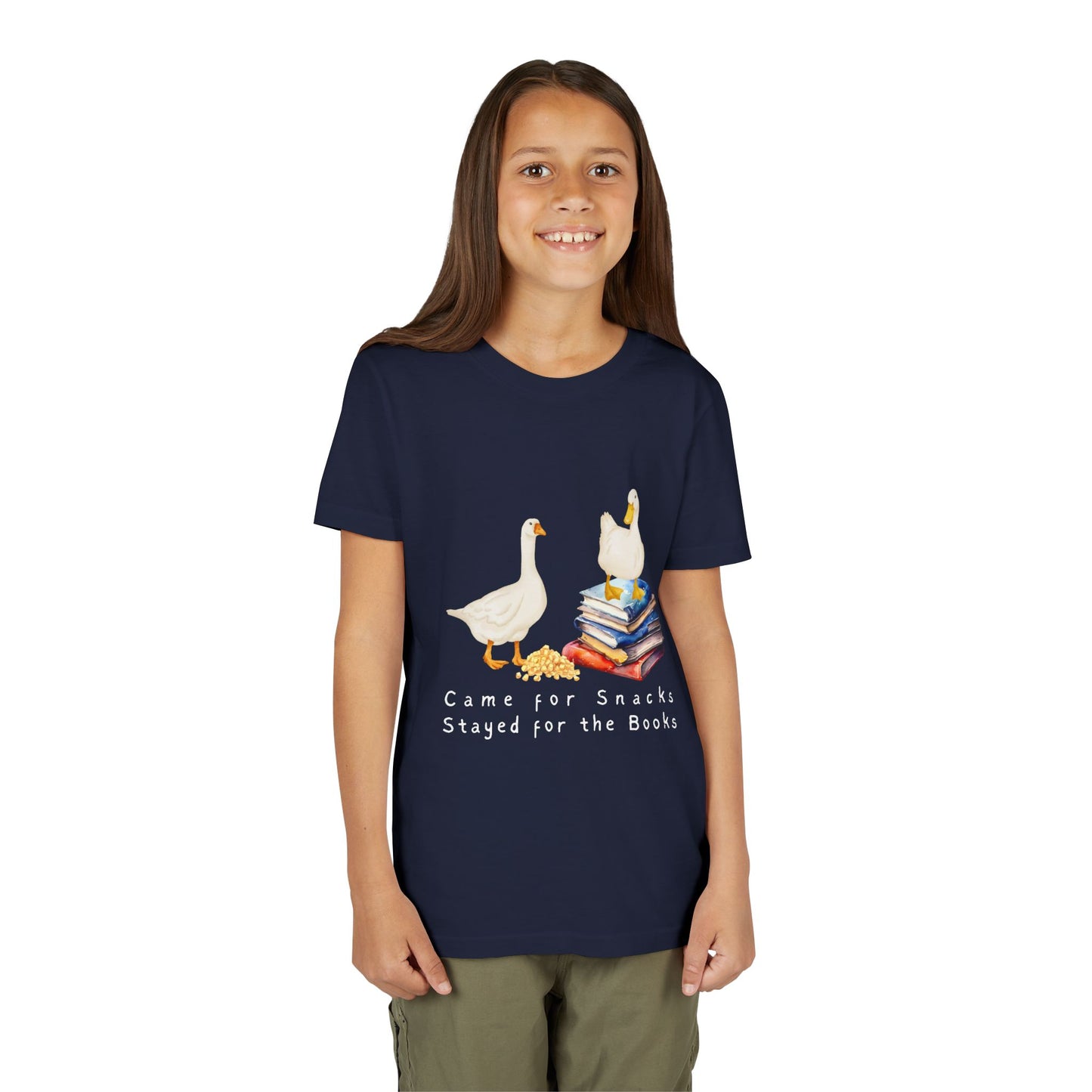 Girl wearing a navy blue t-shirt with cartoon ducks, snacks, books and text 'Came For Snacks Stayed For The Books'